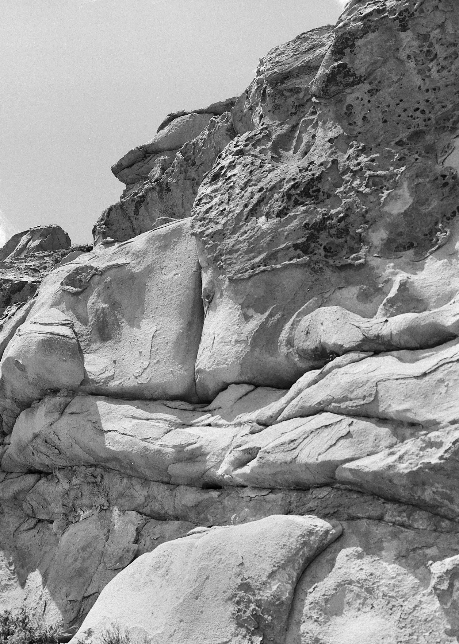 Close-up view of large, textured rocks and boulders outdoors in black and white.