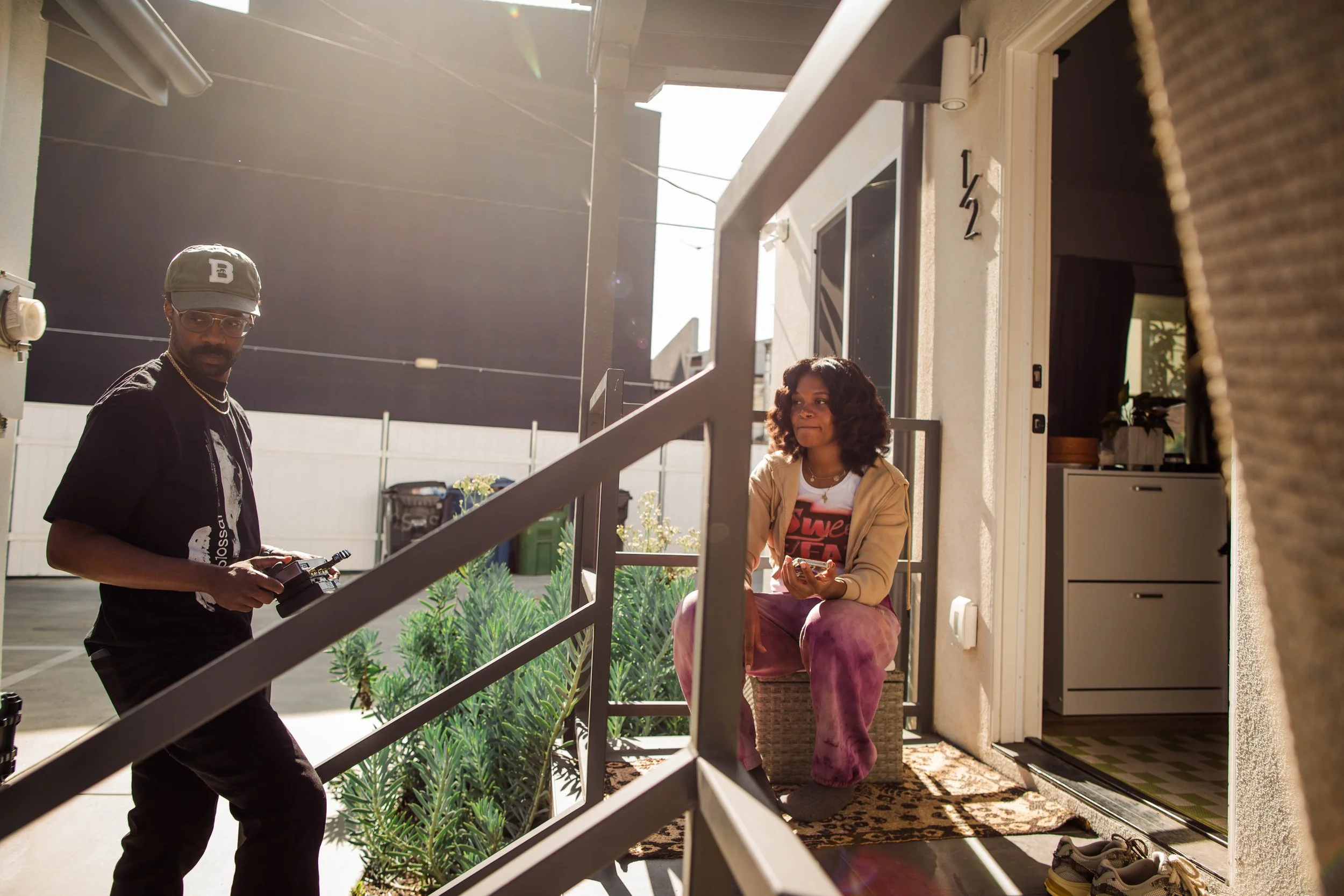 a black woman and black man hanging out on a staircase