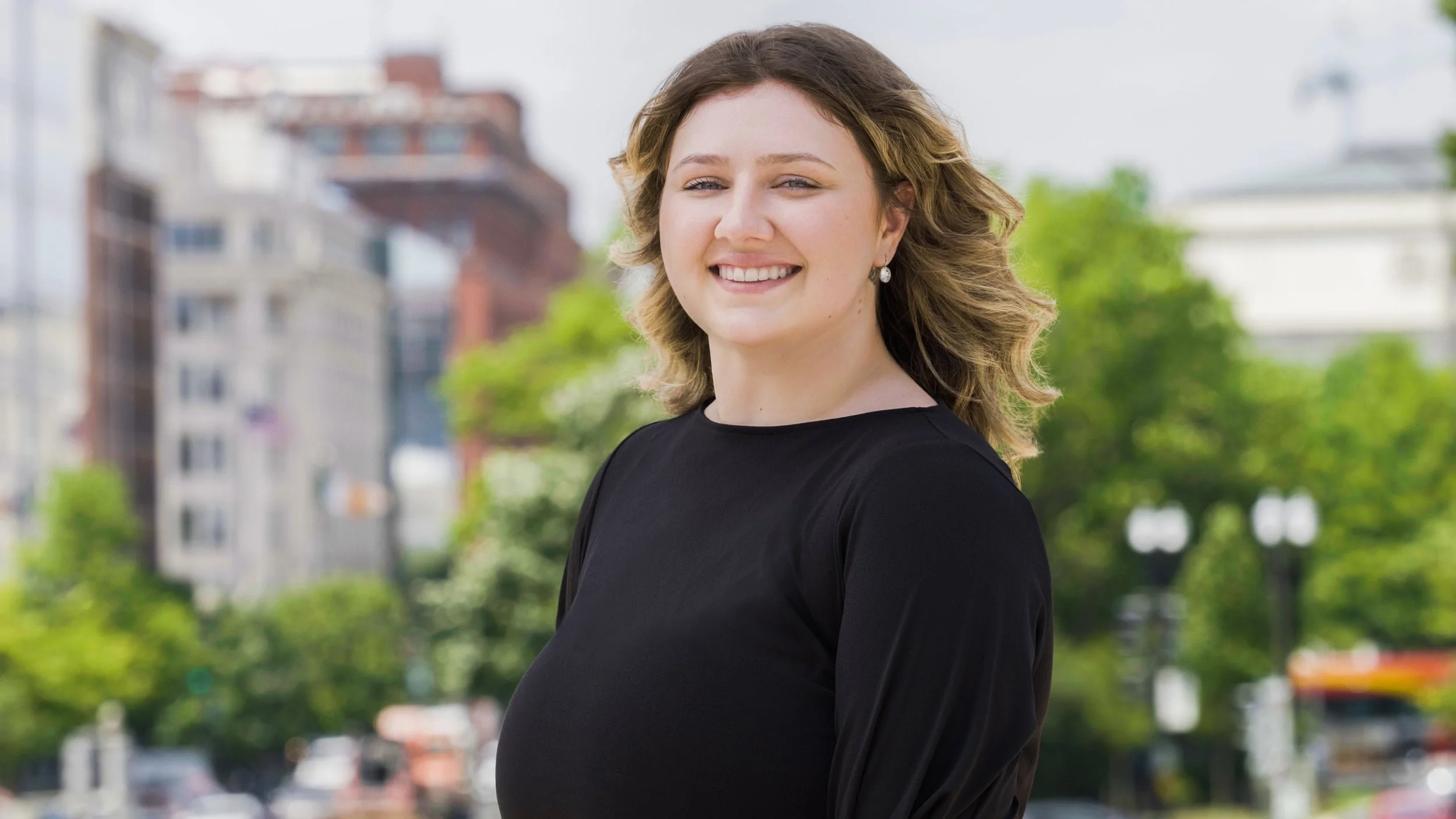 a young professional woman poses for a headshot outdoors in Washington DC