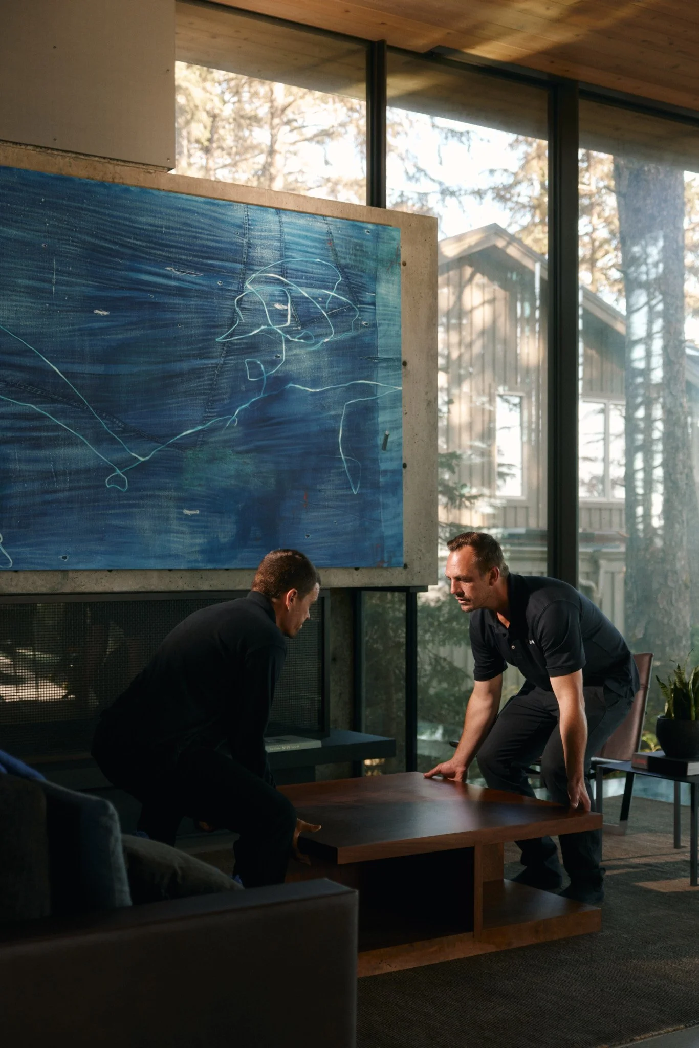 S2N Delivery team carefully positioning a designer coffee table during a white-glove furniture installation in a modern Vancouver home.