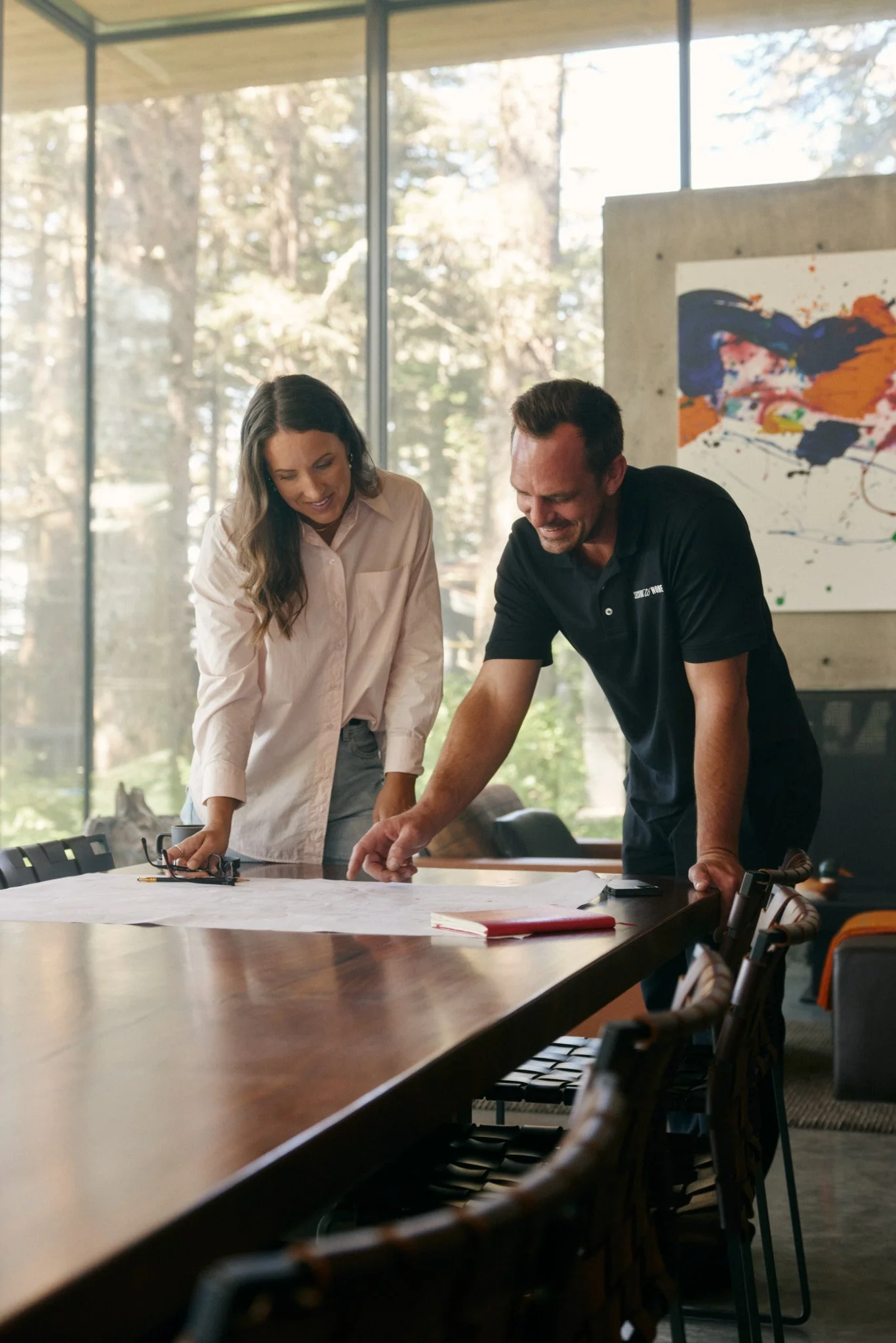 Designer and S2N employee reviewing architectural plans in a modern office, showcasing precision and collaboration.