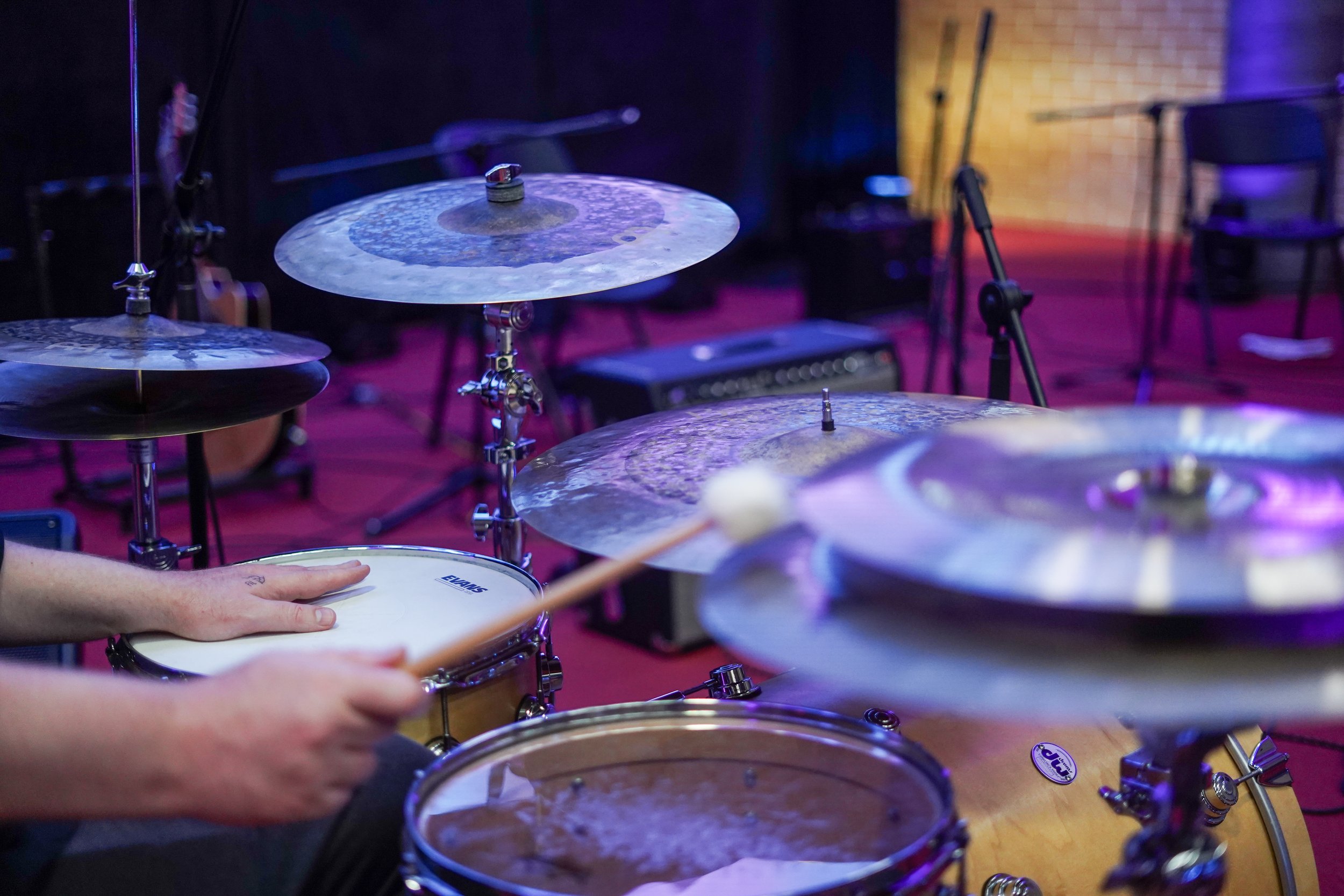 Drum set with cymbals being played with drumsticks in a music studio.