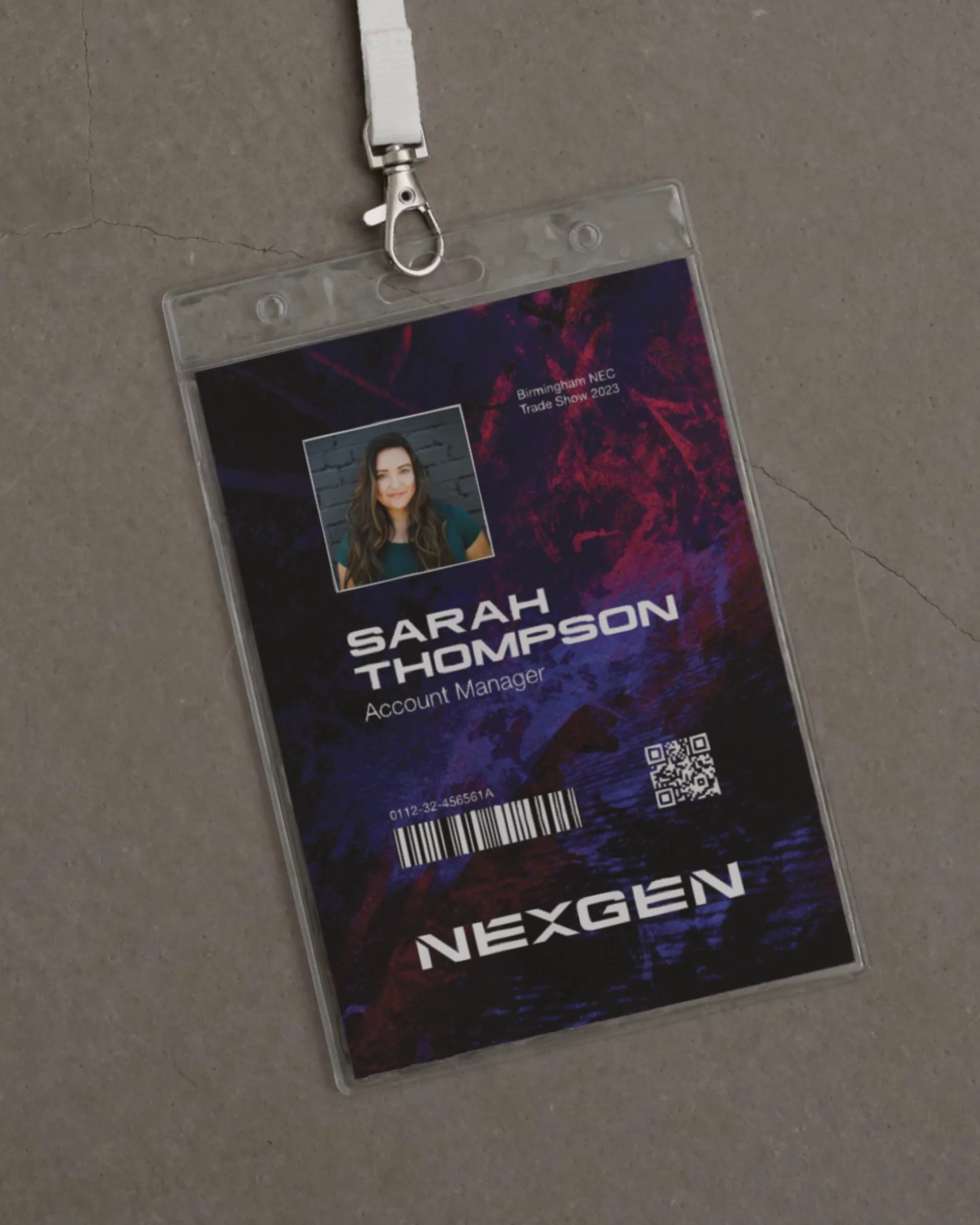A plastic badge holder with a lanyard, containing an ID card for Sarah Thompson, an Account Manager. The ID includes a photo, barcode, QR code, and event details for Birmingham NEC Trade Show 2023, with the branding 'NexGen' at the bottom.