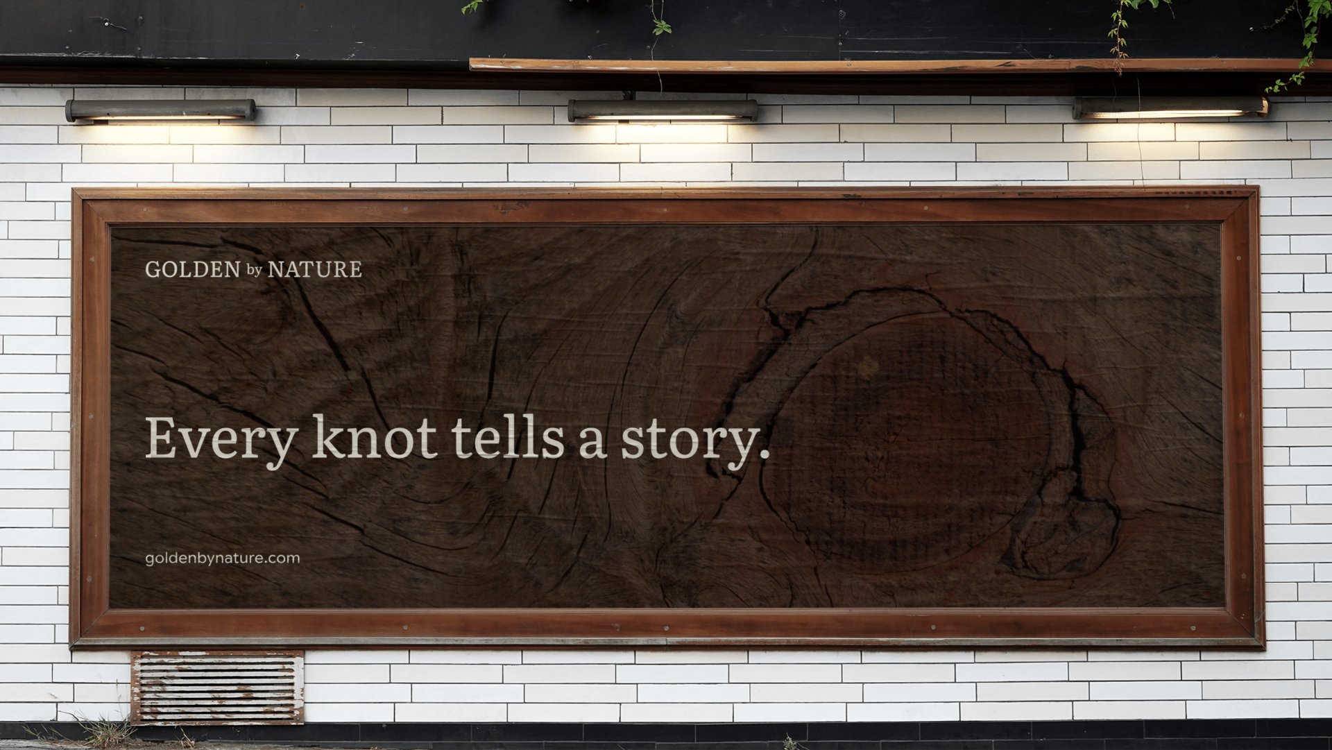 A large outdoor sign with a wooden frame and dark wood grain background displaying the text "Every knot tells a story" in large white letters, with smaller text "GOLDEN by NATURE" in the top left corner and a website URL below.