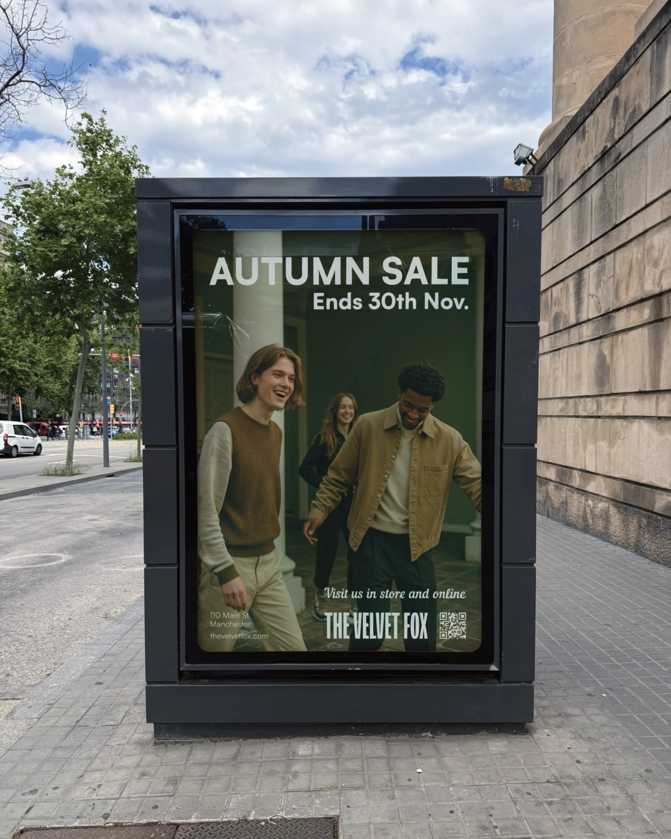 A bus stop poster advertising an autumn sale ending November 30th, showing three people smiling and walking inside the store. The store is called The Velvet Fox, located at 110 Main St, Manchester. The poster encourages visiting in store and online.