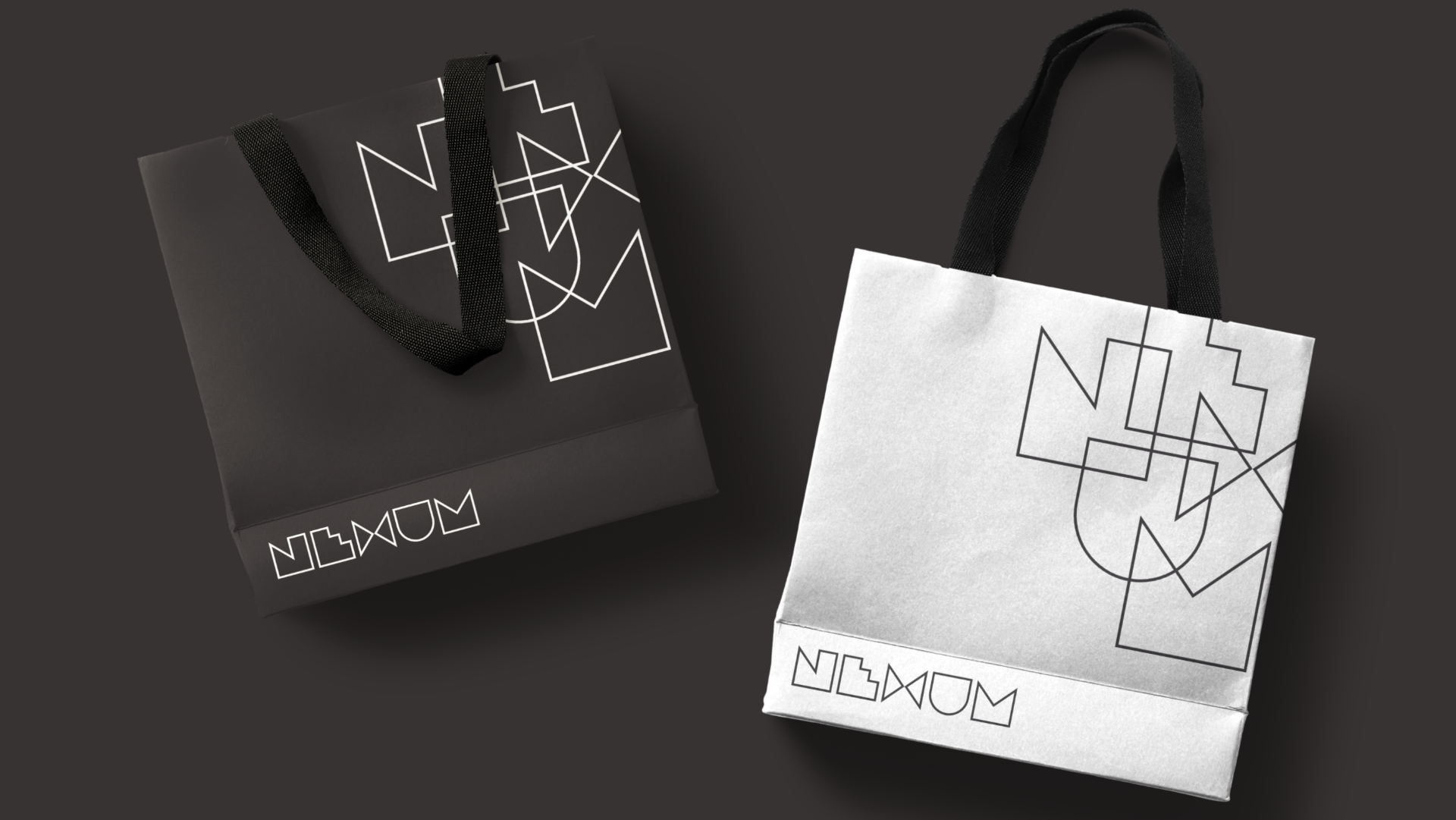Two shopping bags, one black and one white, with geometric line art designs and the word 'NOUN' printed on the black bag.