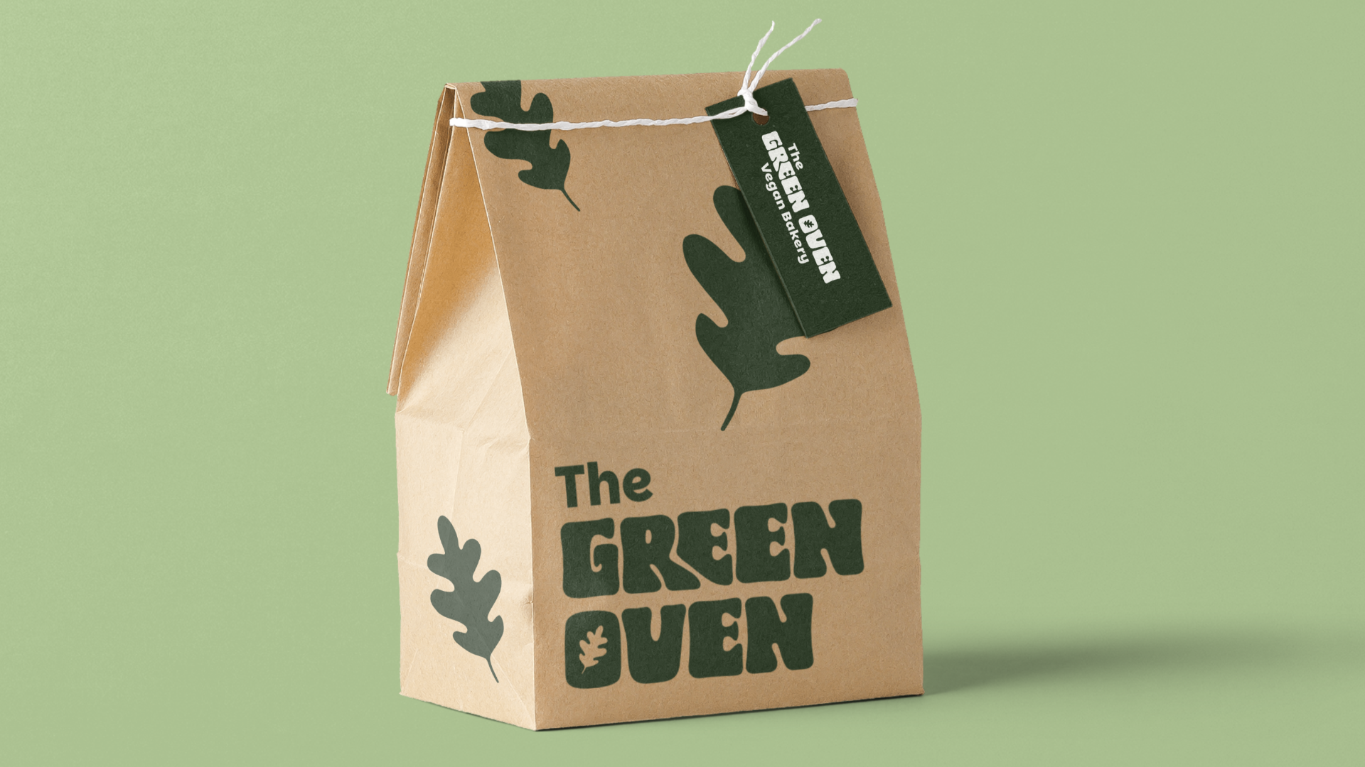 Brown paper bag with green leaf illustrations and black text reading "The Green Queen" on a light green background.