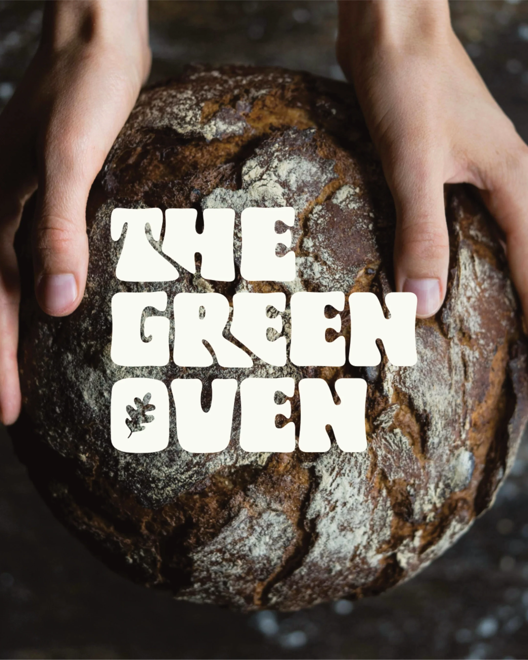 Hands holding a rustic, cracked loaf of bread with the words 'The Green Queen' overlaid in white, stylized text.