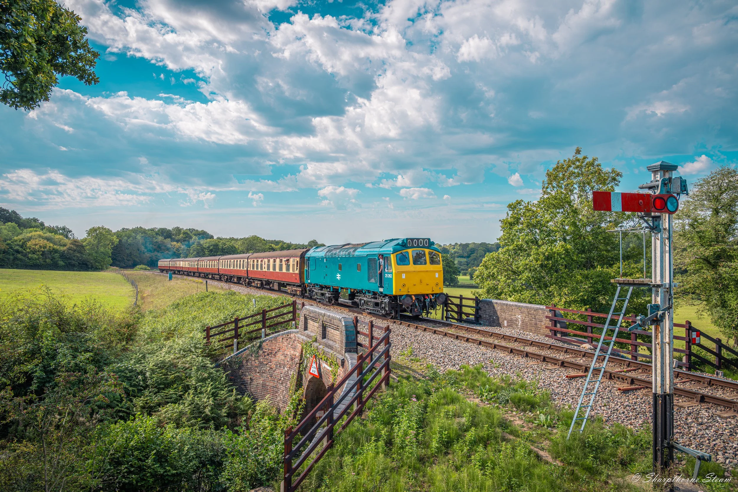 Sunny Rat - No25262 running early passes over New Road Bridge as she is signal checked before Horsted Keynes station.