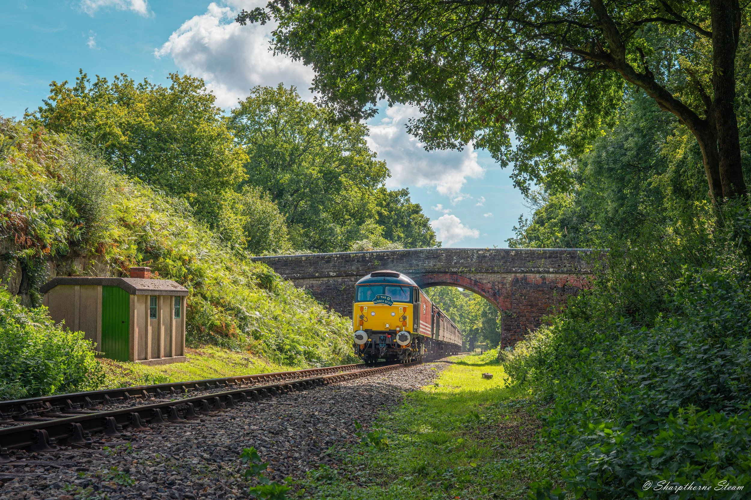 The Sunny Spoon - No47715 passes under Birchstone Bridge as she descends the gradient into Kingscote.