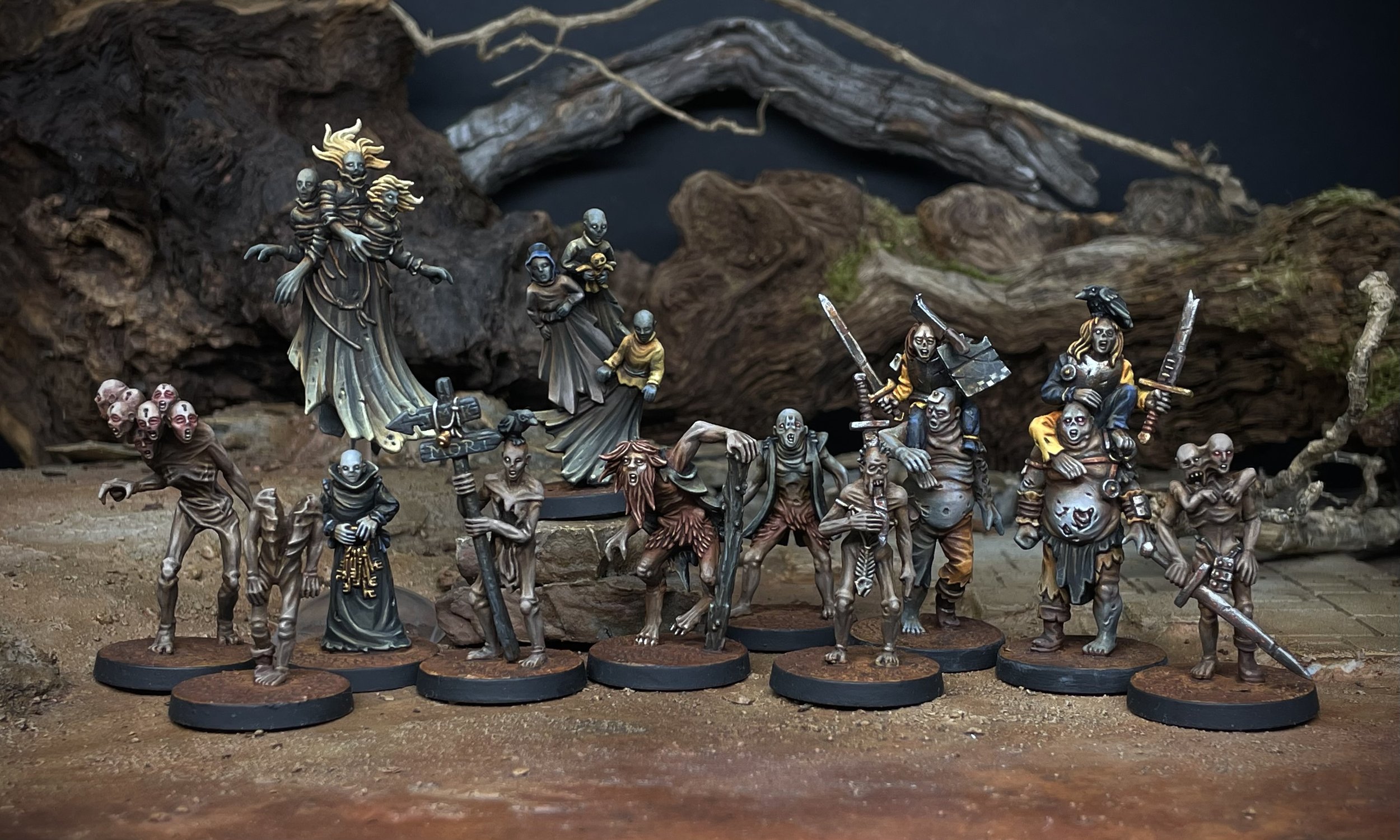 Hand-painted fantasy miniatures on display, depicting various Black Crab grotesque and eerie creatures in detailed poses, set against a dark, natural-looking backdrop.