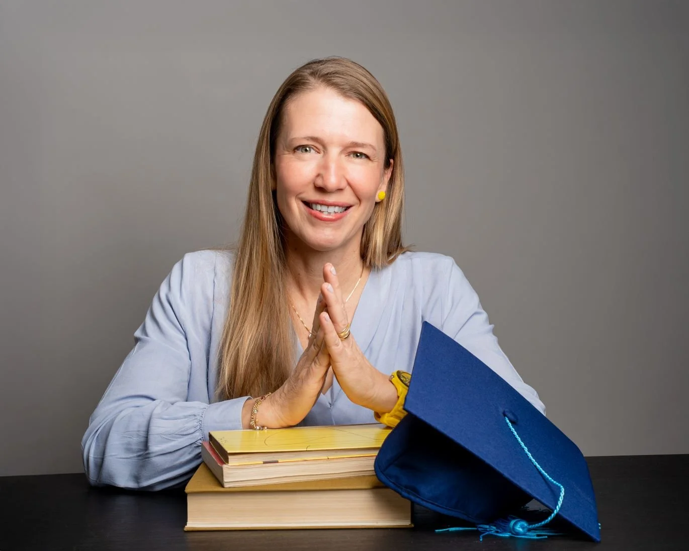 Bianca Grau mit hellblauer Bluse und Doktorenhut.