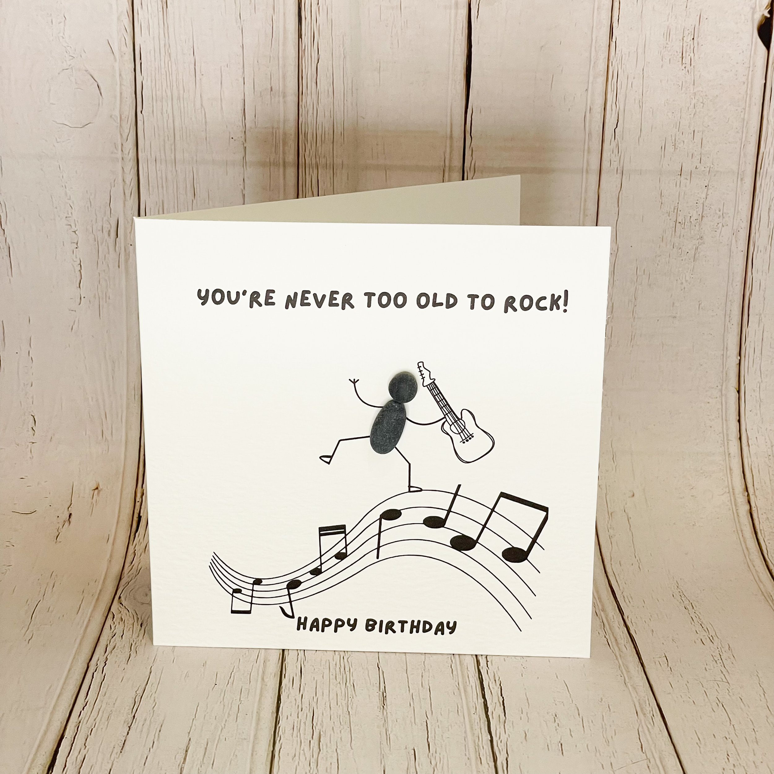 handmade 6 x 6 inch birthday card with dancing pebble man & music note heart. Blank inside, textured cardstock, envelope & cello bag included