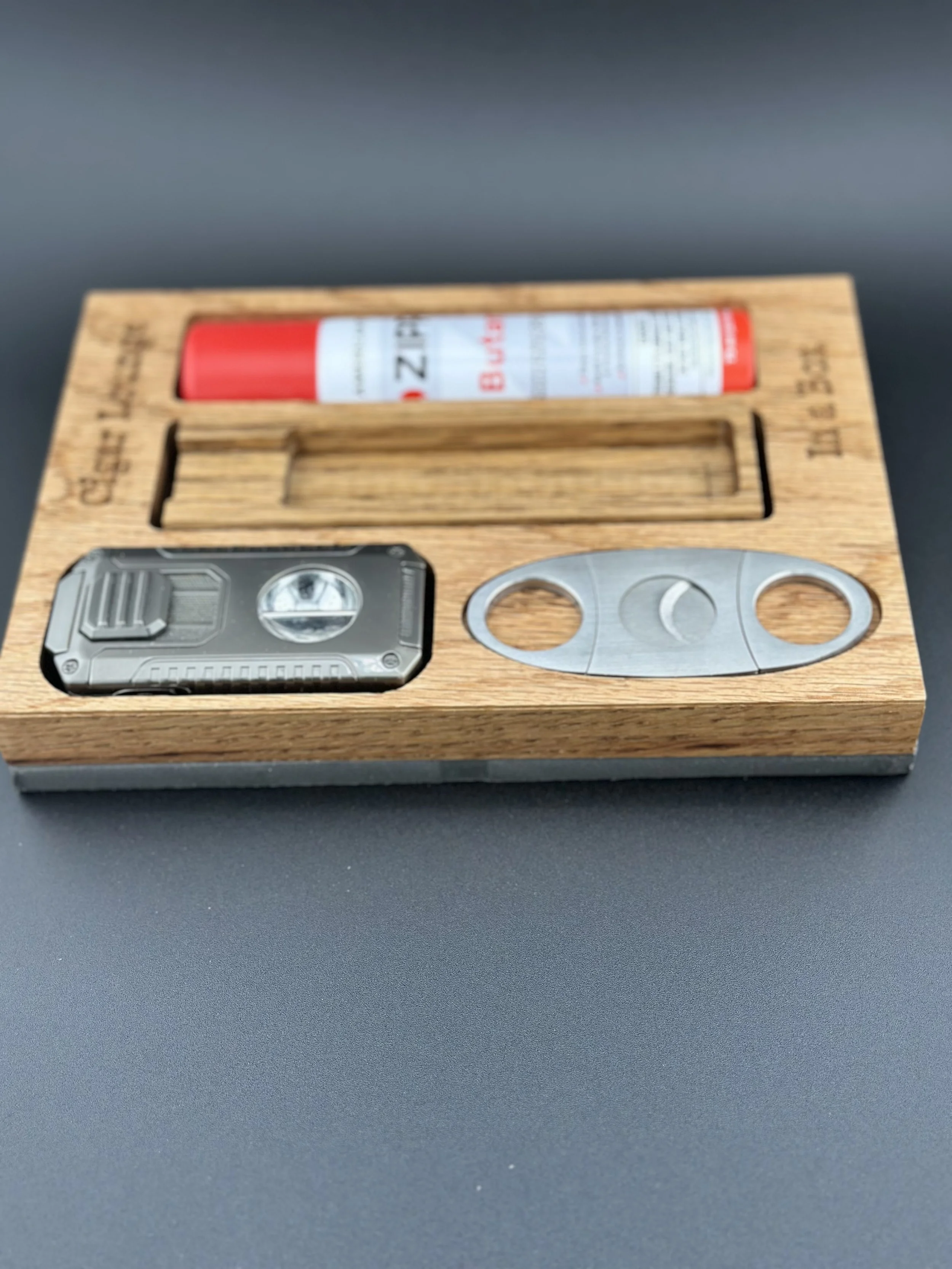 Wooden box containing a small flashlight, a metal bottle opener, and a tube of lubricant.