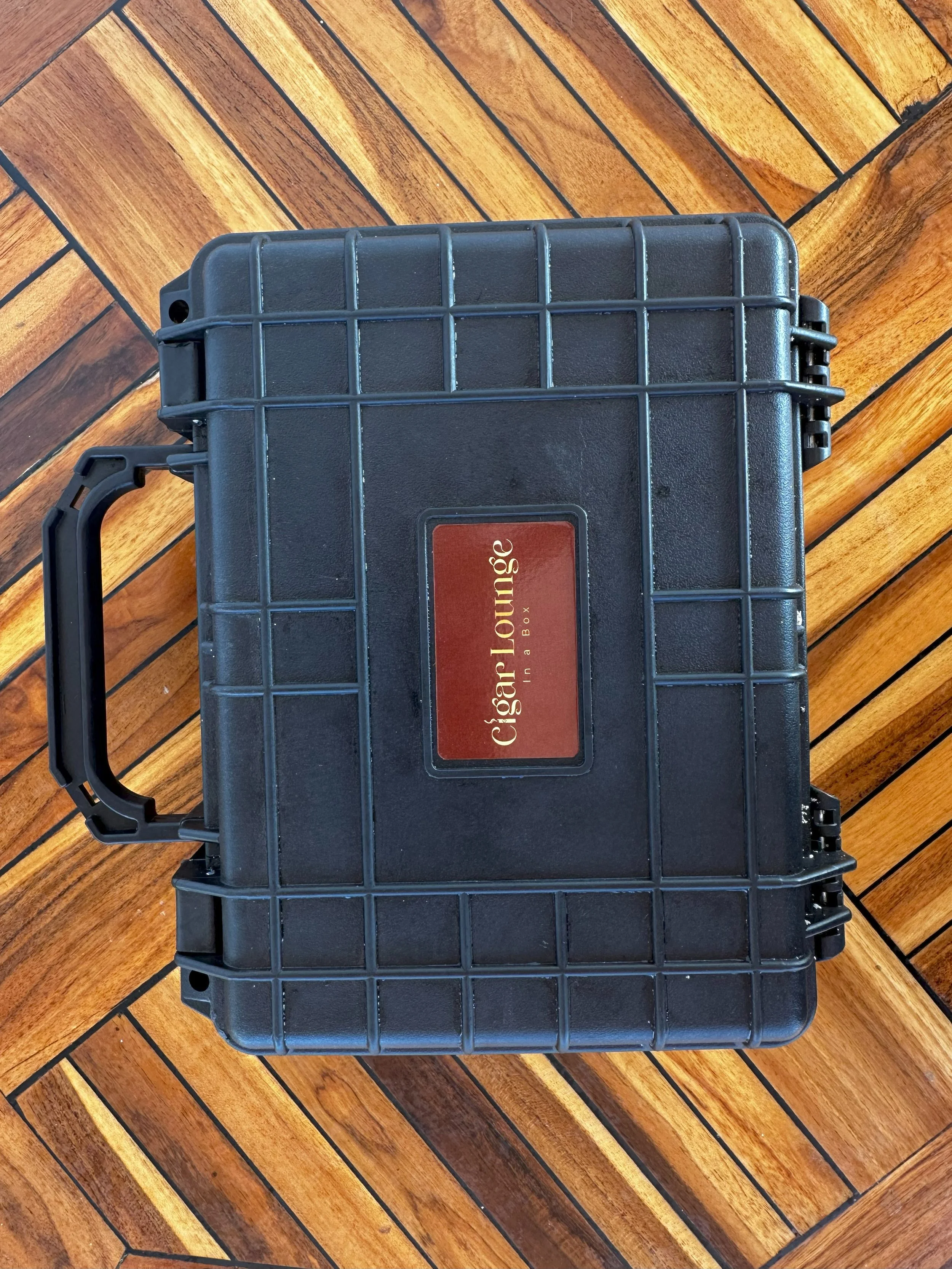Black Cigar Lounge branded briefcase resting on a wooden surface.