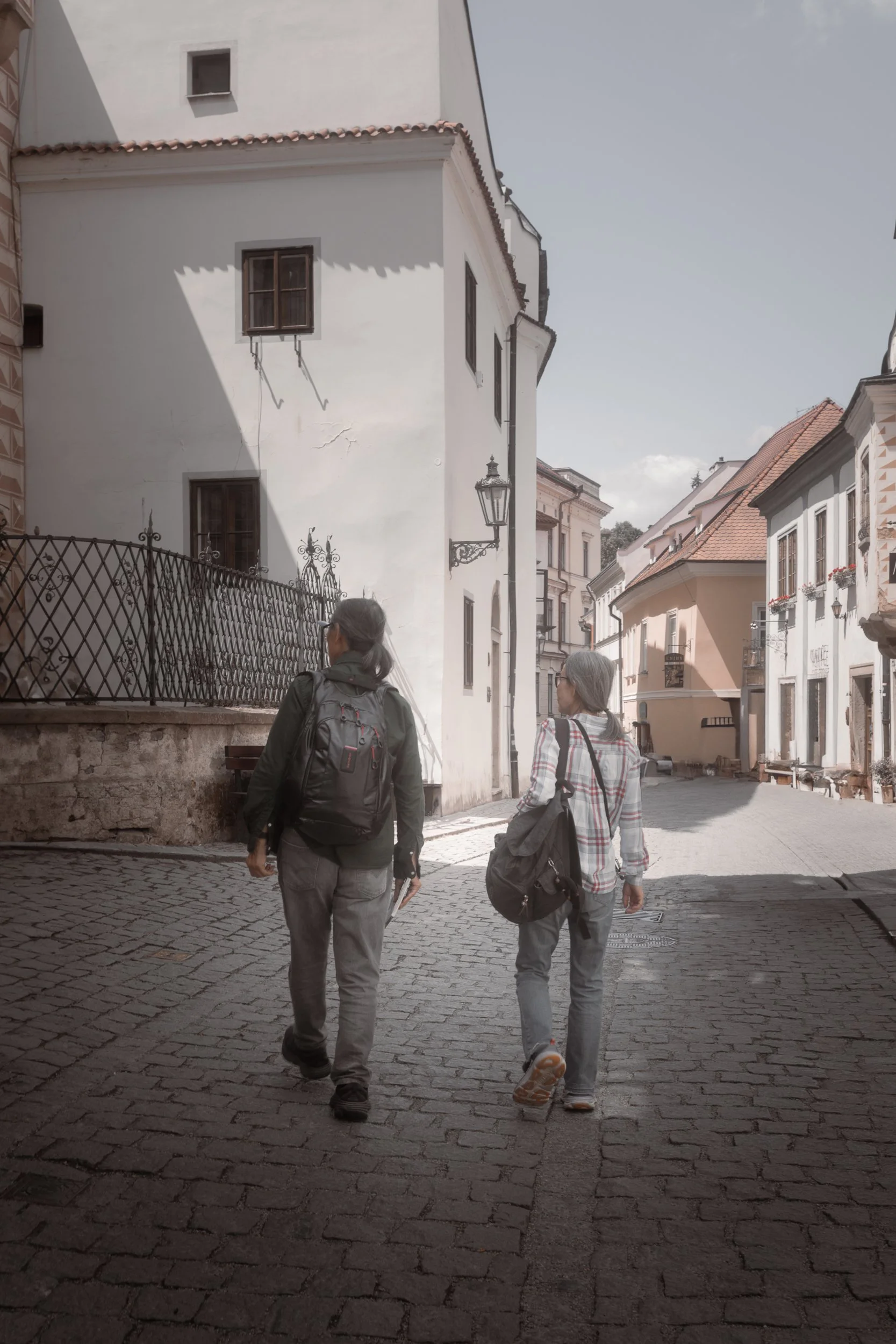 2 elderly Korean travellers wandering through the picturesque streets of Cesky Krumlov, Czech Republic.