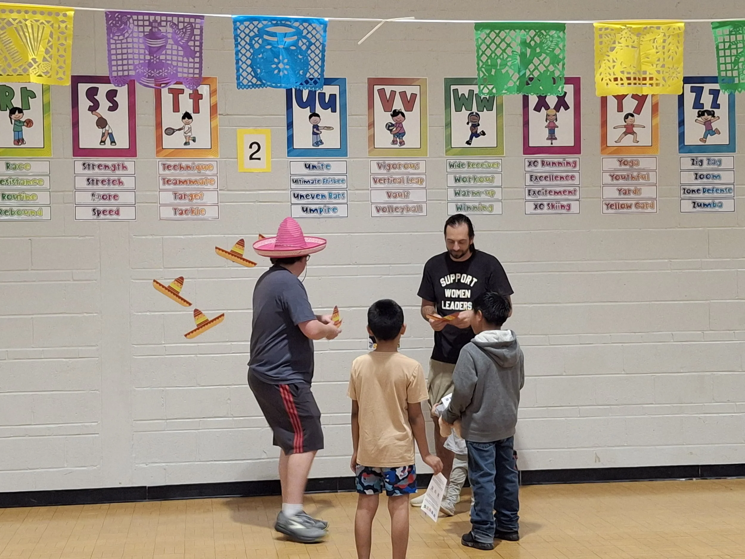 A volunteer helps elementary school kids play games at a hispanic heritage night to celebrate hispanic culture at Cherrydale Elementary school. 