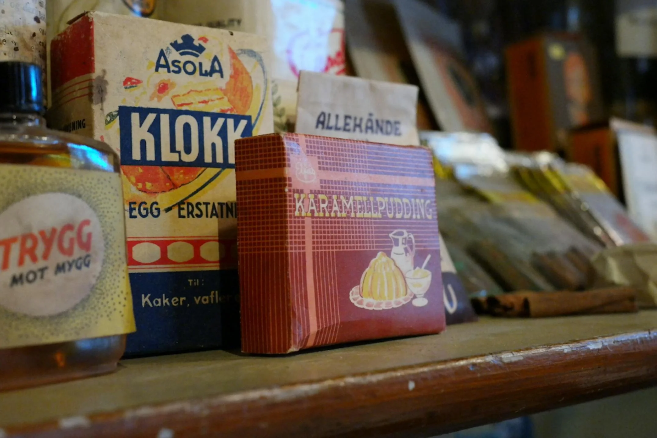 Ulike bakevarer og ingrediensposer på en hylle, inkludert egg-erstatning og karamellpudding.