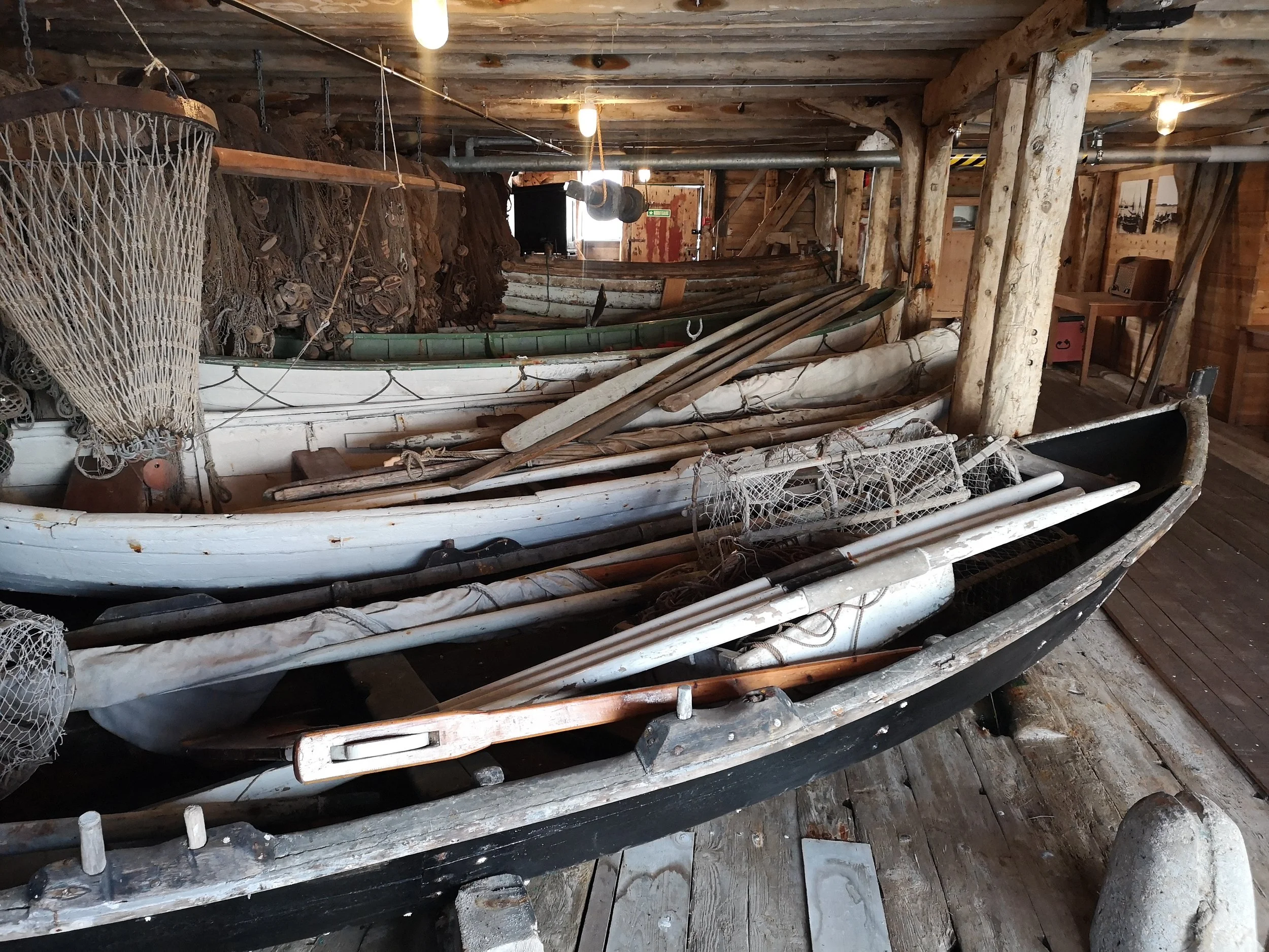 Et rom med norske skute, tauverk og fiskenett i en gammel trehytte.