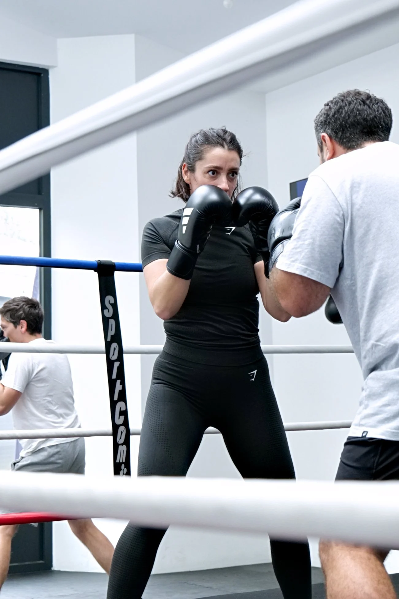 Femme s'entraînant sur le ring de boxe avec un coach chez United Boxing.
