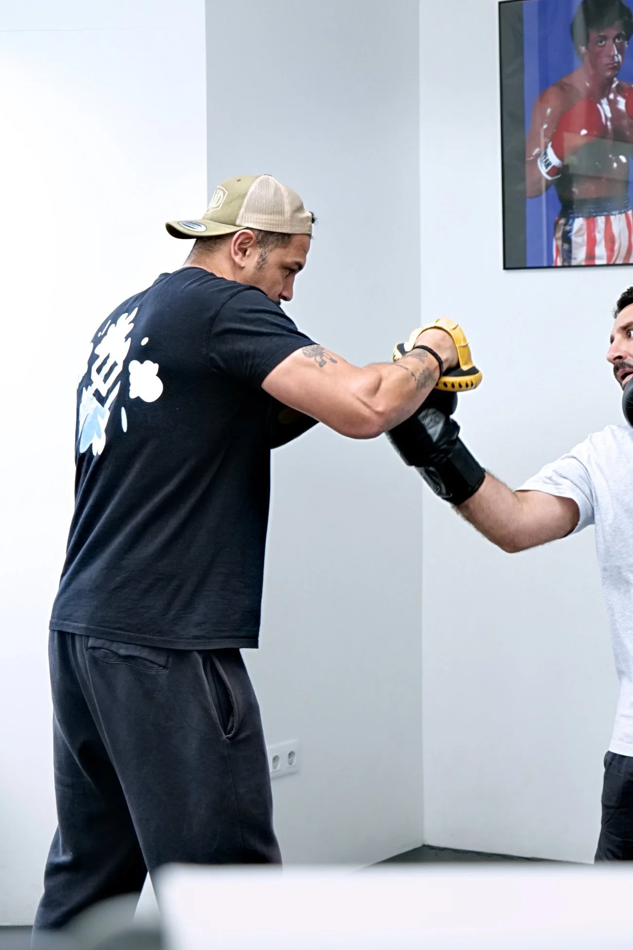 Abdelkader Bouhenia coachant un élève aux pattes d'ours pour la technique de boxe.