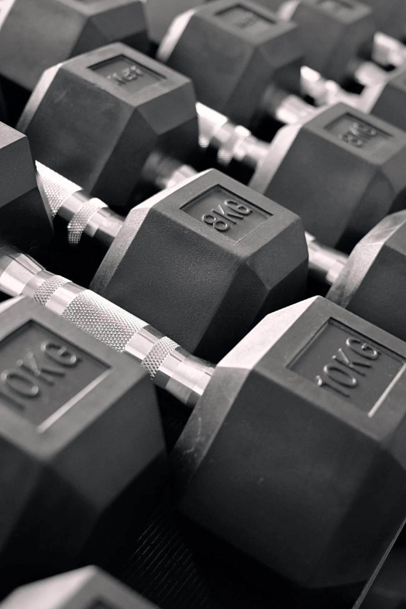 Gros plan sur des haltères de 8kg et 10kg dans la salle de sport à Colombes.