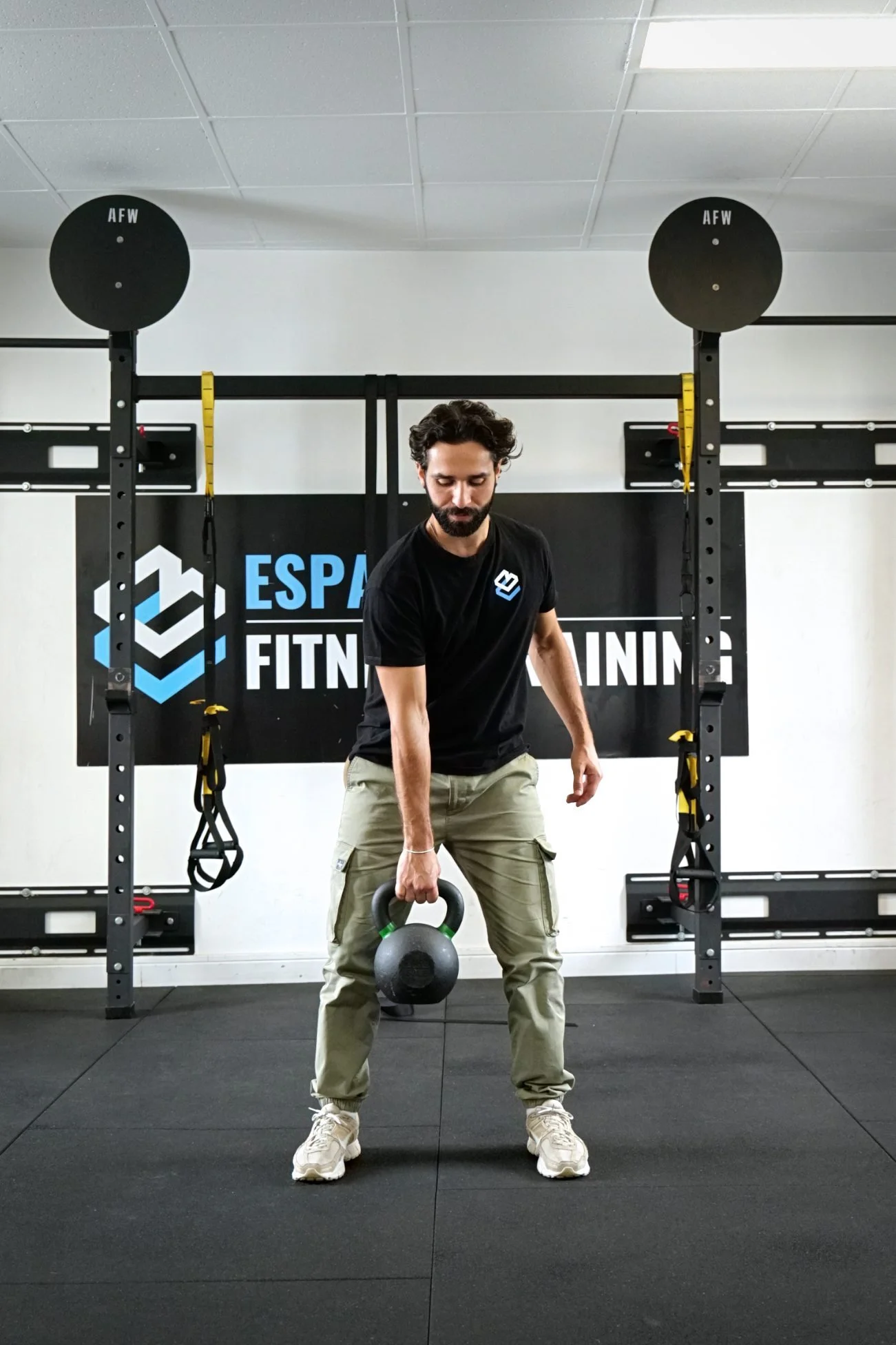 Coach pratiquant le cross-training avec kettlebell dans l'espace fitness de United Boxing.