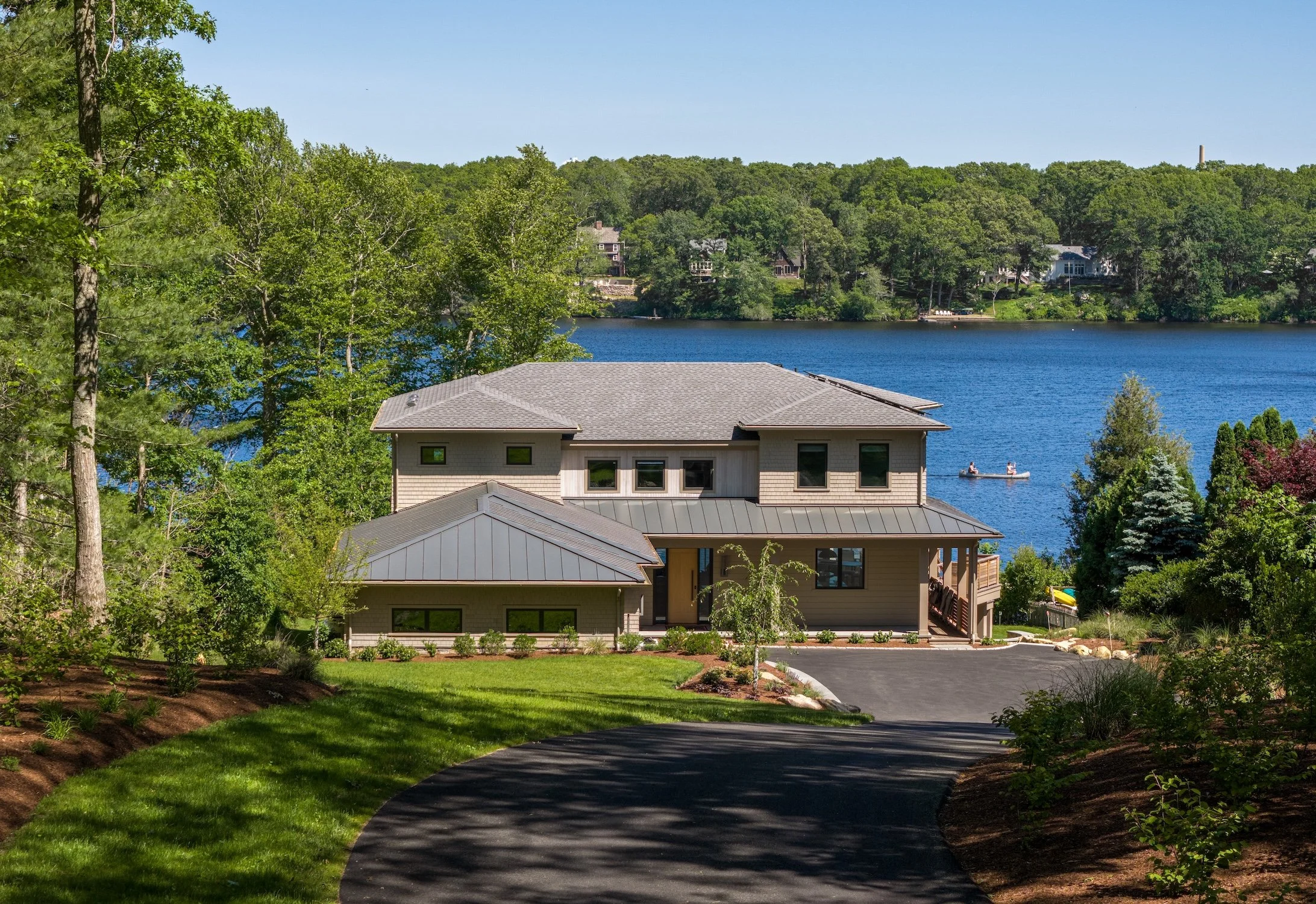 Luxury waterfront custom home with modern coastal architecture, landscaped grounds, and panoramic water views.