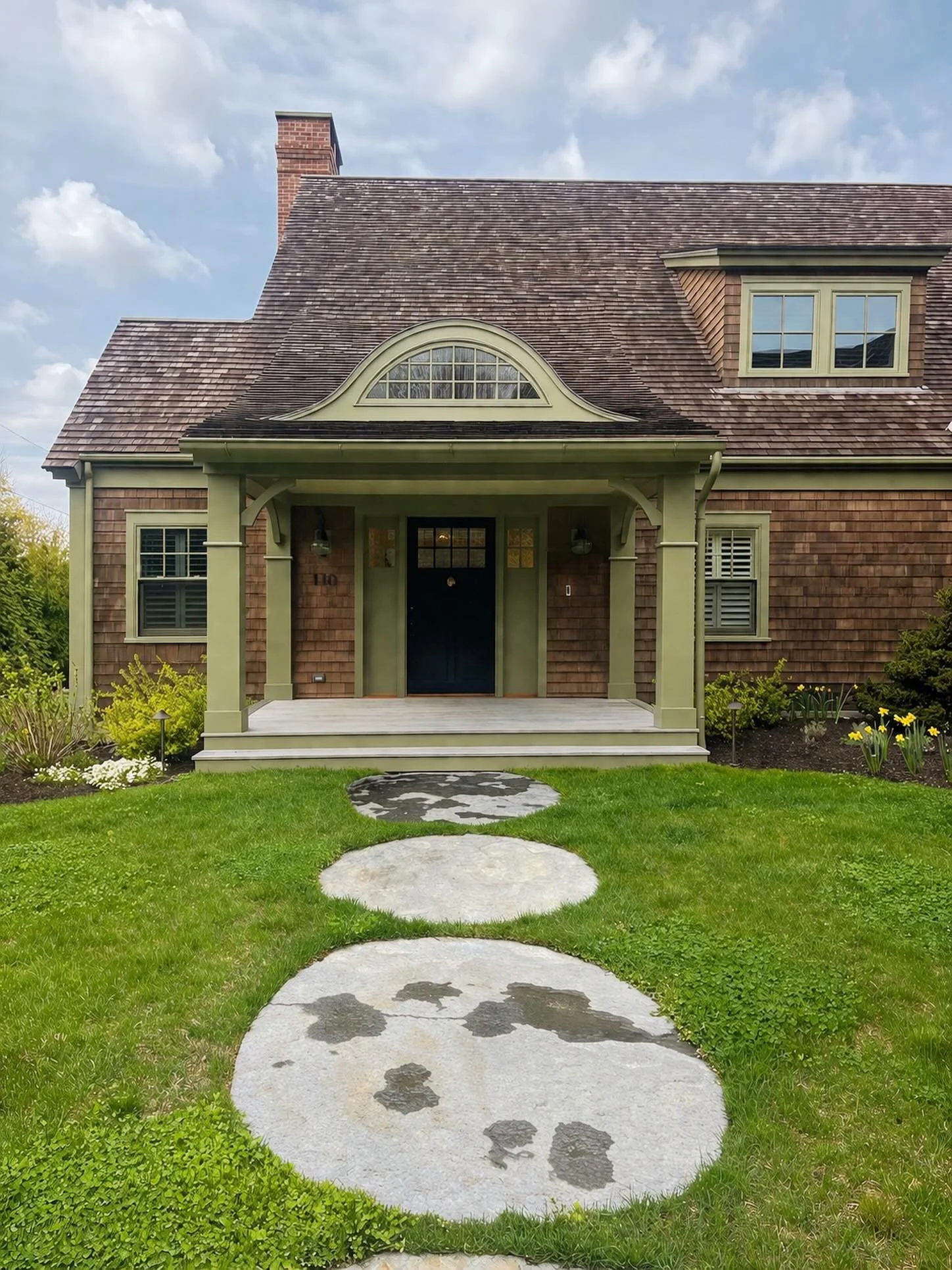 A front entry that sets the tone before you even walk through the door.

From the sweeping roofline and eyebrow dormer to the cedar shingles, handcrafted details, and timeless proportions &mdash; every line of this home was designed to feel both eleg