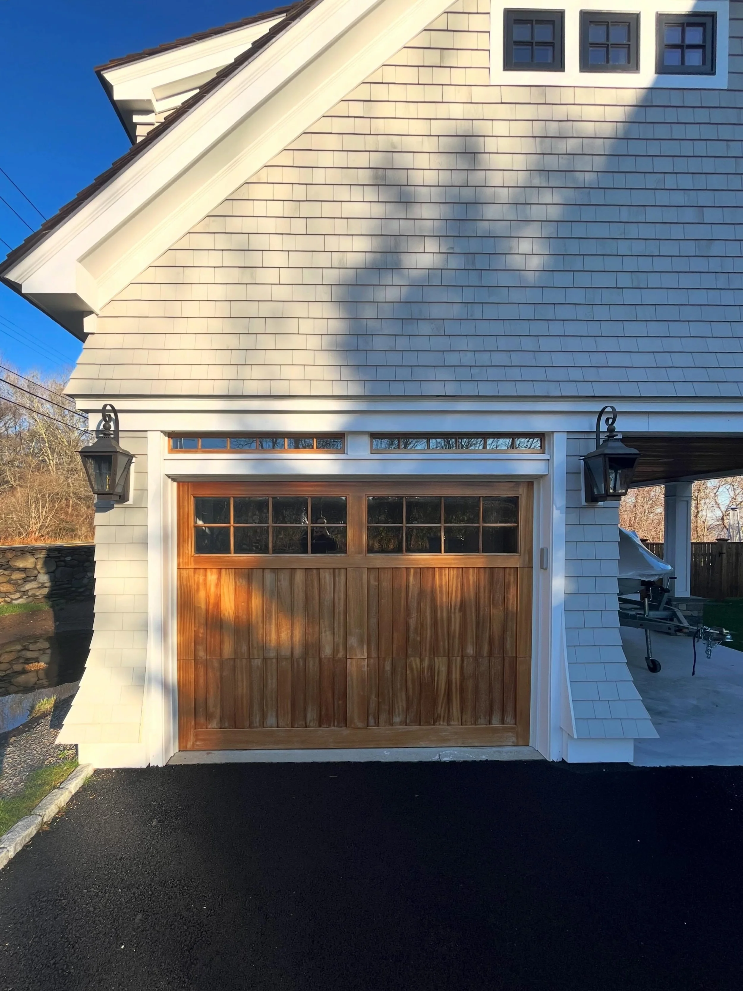 It&rsquo;s the details that elevate a garage from functional to architectural.
The custom shingle flares bring depth, movement, and timeless coastal character to this elevation &mdash; paired with crisp trim work, cedar garage doors, and classic lant