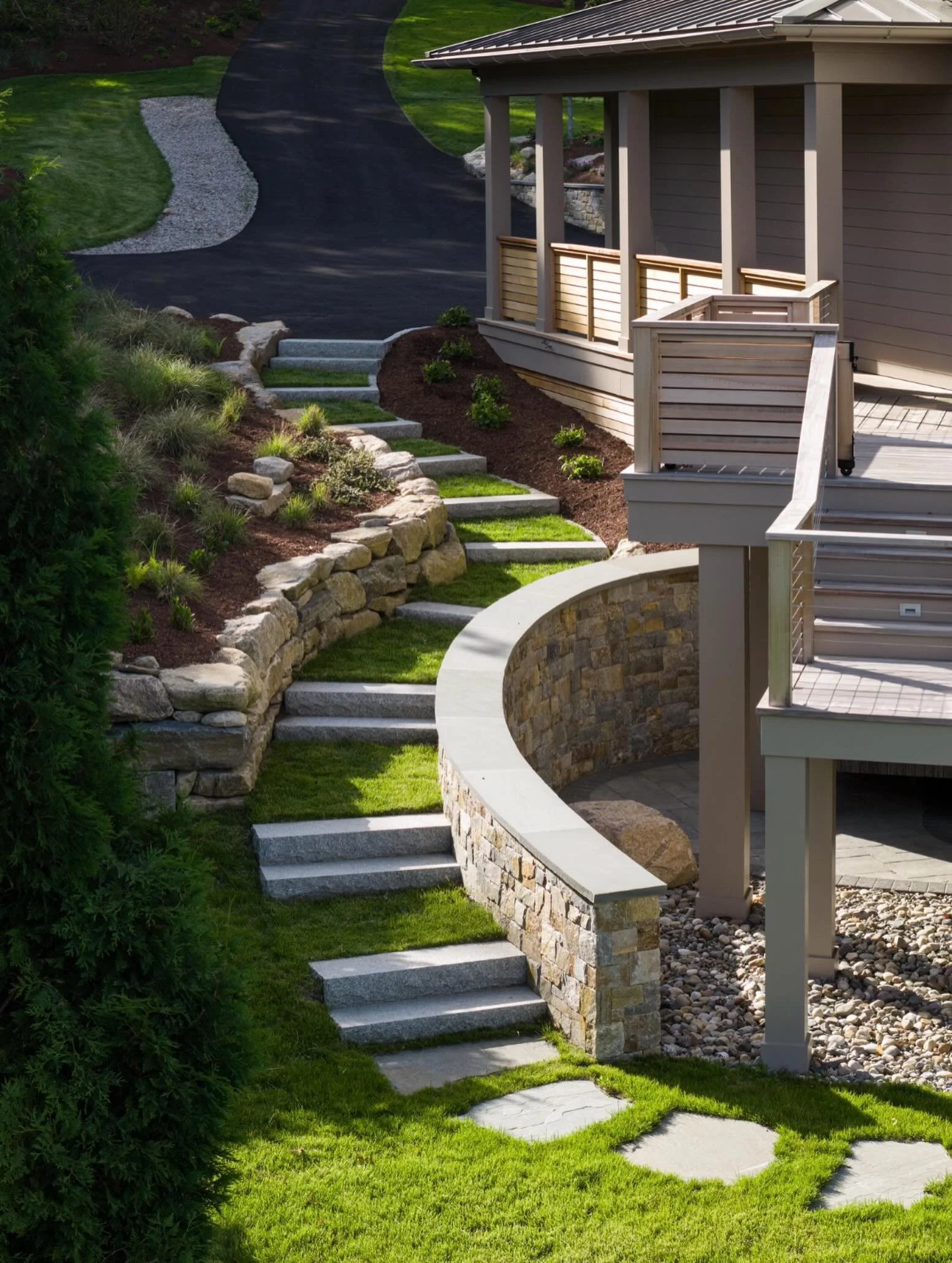 The best landscapes don&rsquo;t just connect spaces&mdash;they create an experience. 🌿

Natural stone walls, granite steps, and layered plantings work together to guide you through the property while softening a significant change in grade. Every cu