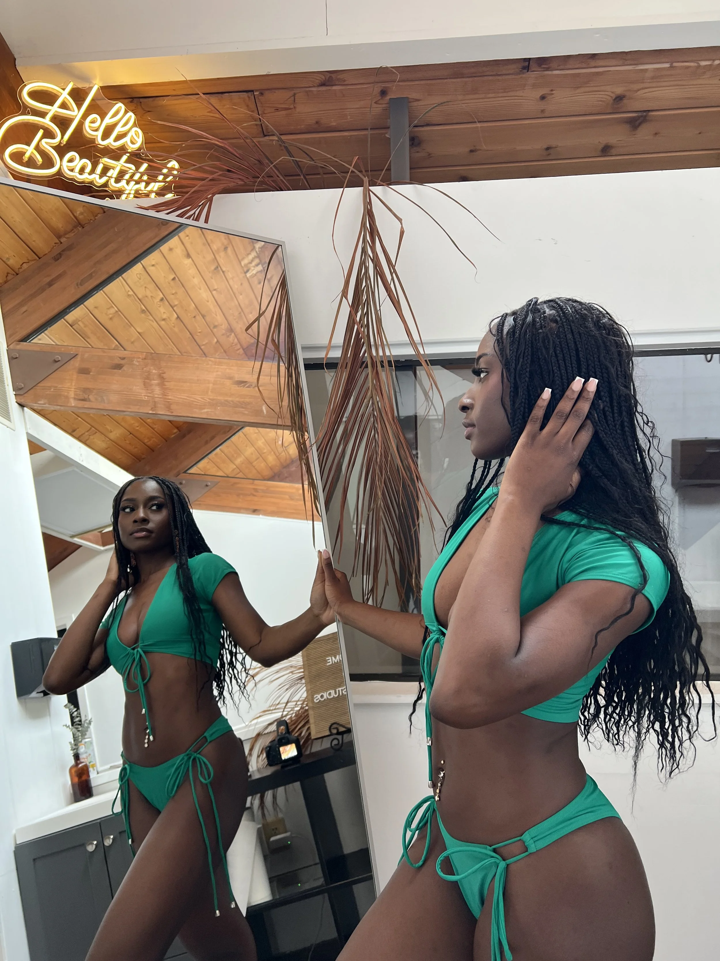 Model wearing green tie bikini walking forward to show movement and stretch. Meena Swims fit guide highlights adjustable swimwear designed for comfort, flexibility, and real body movement.