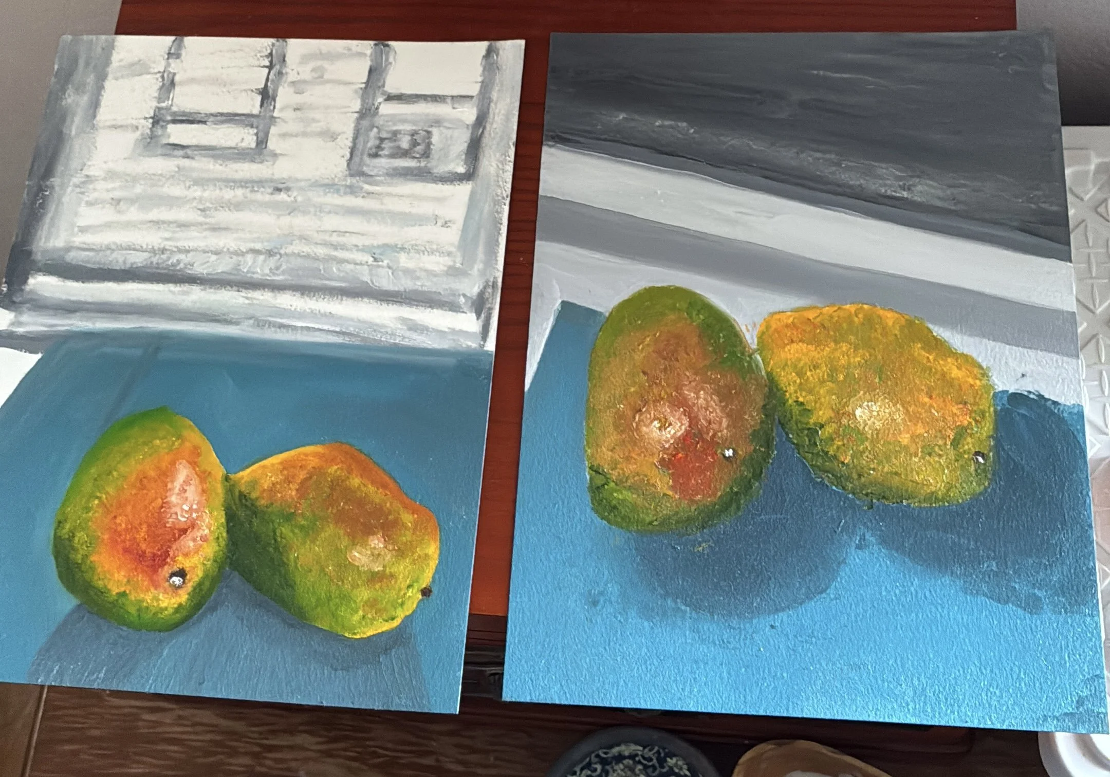 Still life lighting study with ripe mangoes that are sitting on a teal table cloth