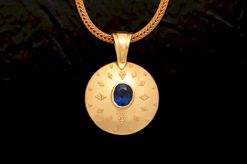 Etruscan-Inspired Hidden Treasures Pendant
Part of the Hidden Treasures Collection, this 18K gold pendant draws inspiration from ancient Etruscan jewelry. The front showcases intricate granulation, centering a 2.25-carat sapphire of extraordinary qua