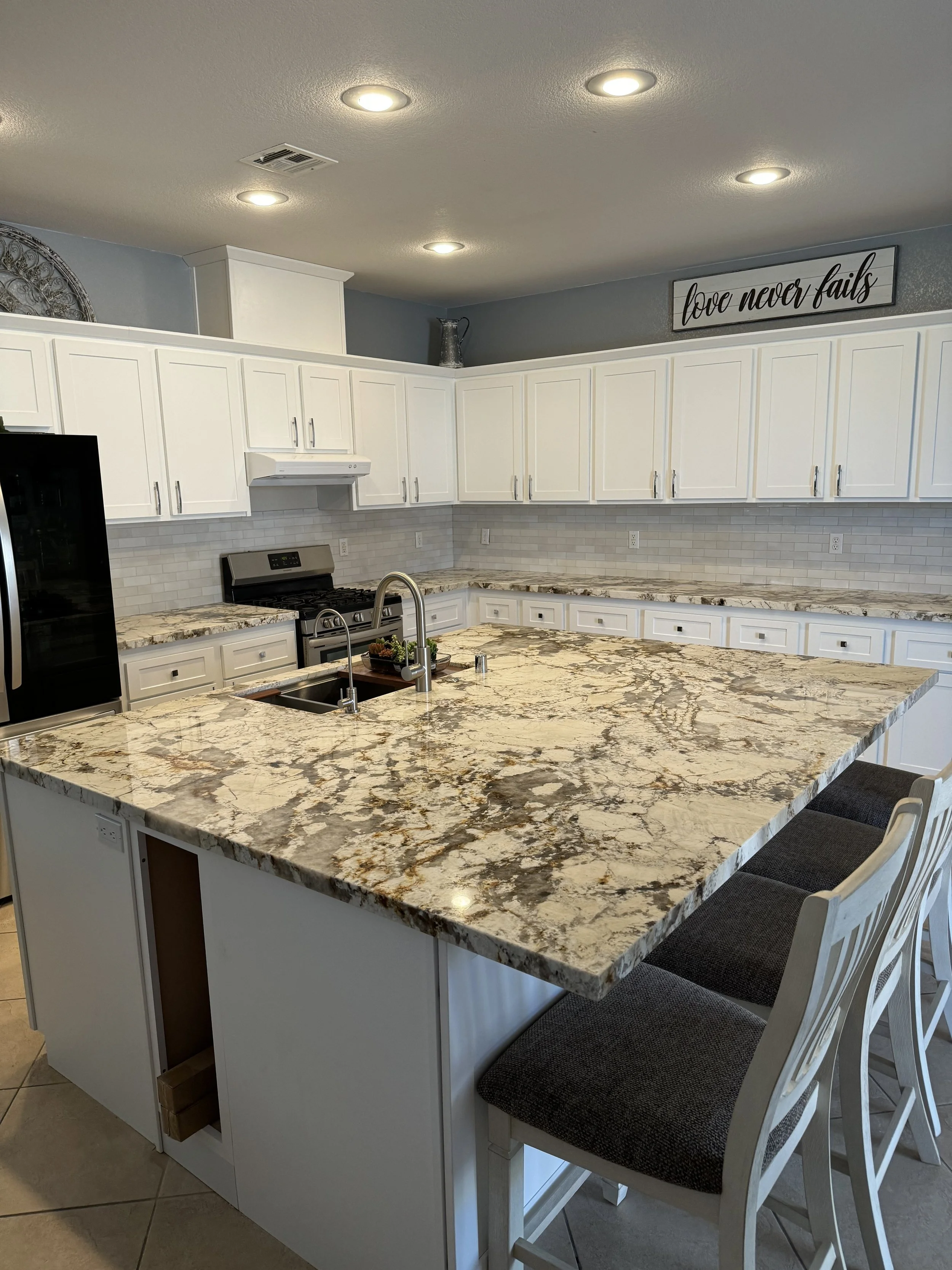 Modern kitchen with white cabinets and marble countertops