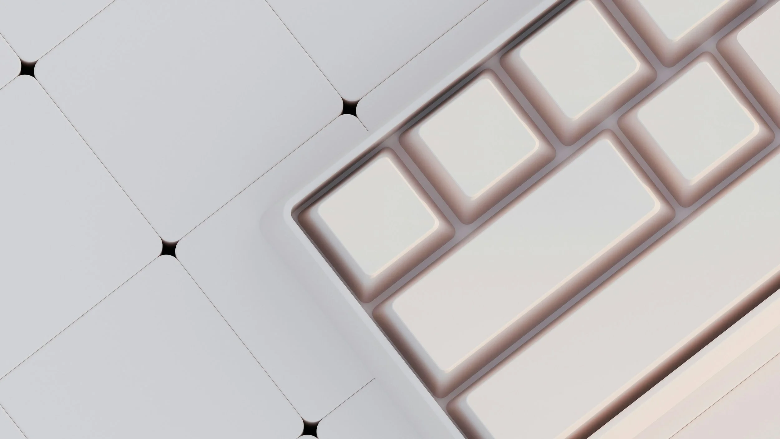 Close-up of a modern white computer keyboard with minimalist design, featuring large square keys and a geometric patterned background.