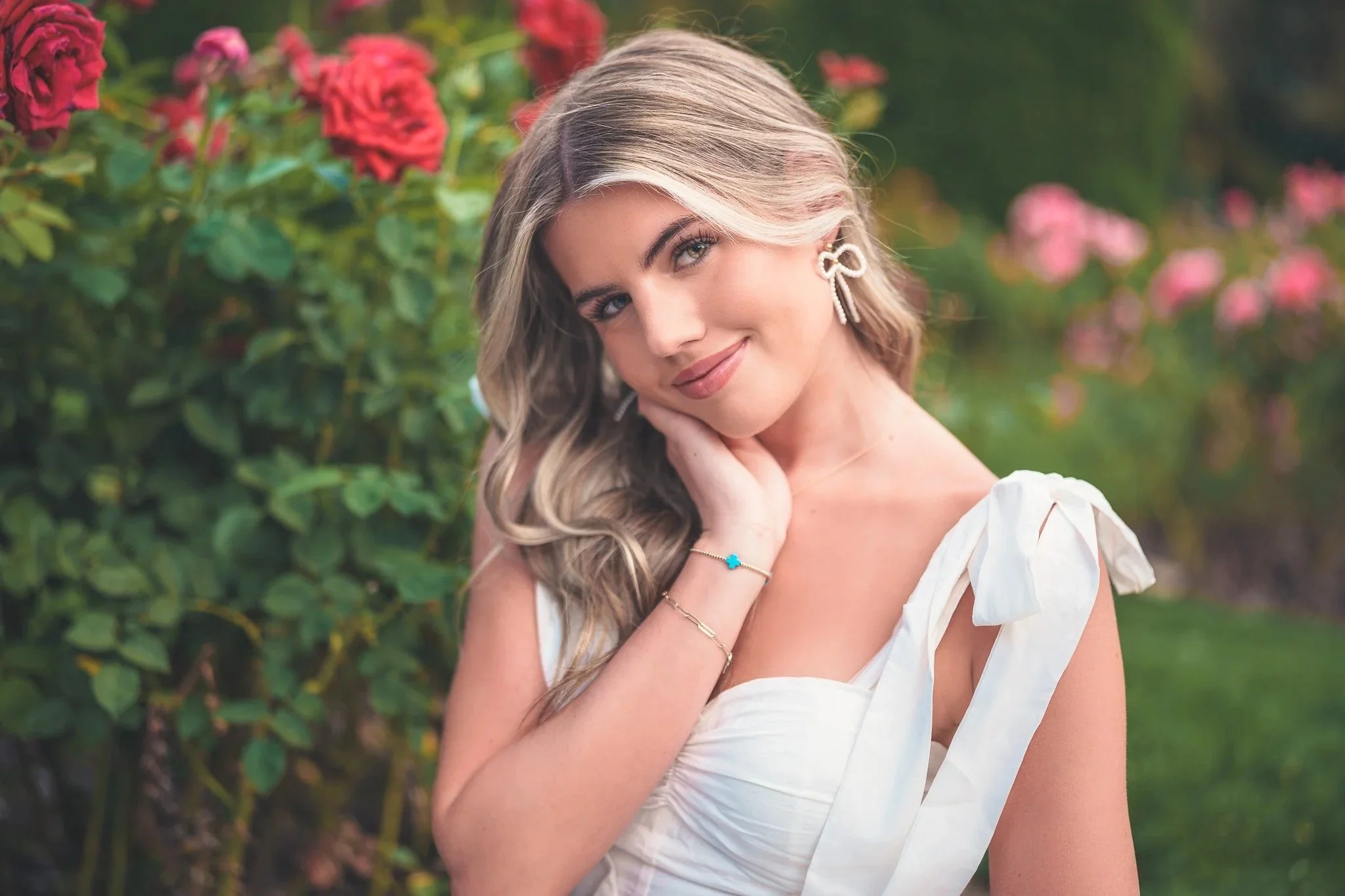 Boise senior photography session at the Rose Garden in Ann Morrison Park featuring a high school senior in a white dress surrounded by blooming roses — natural, timeless portraits by Forever My Media.