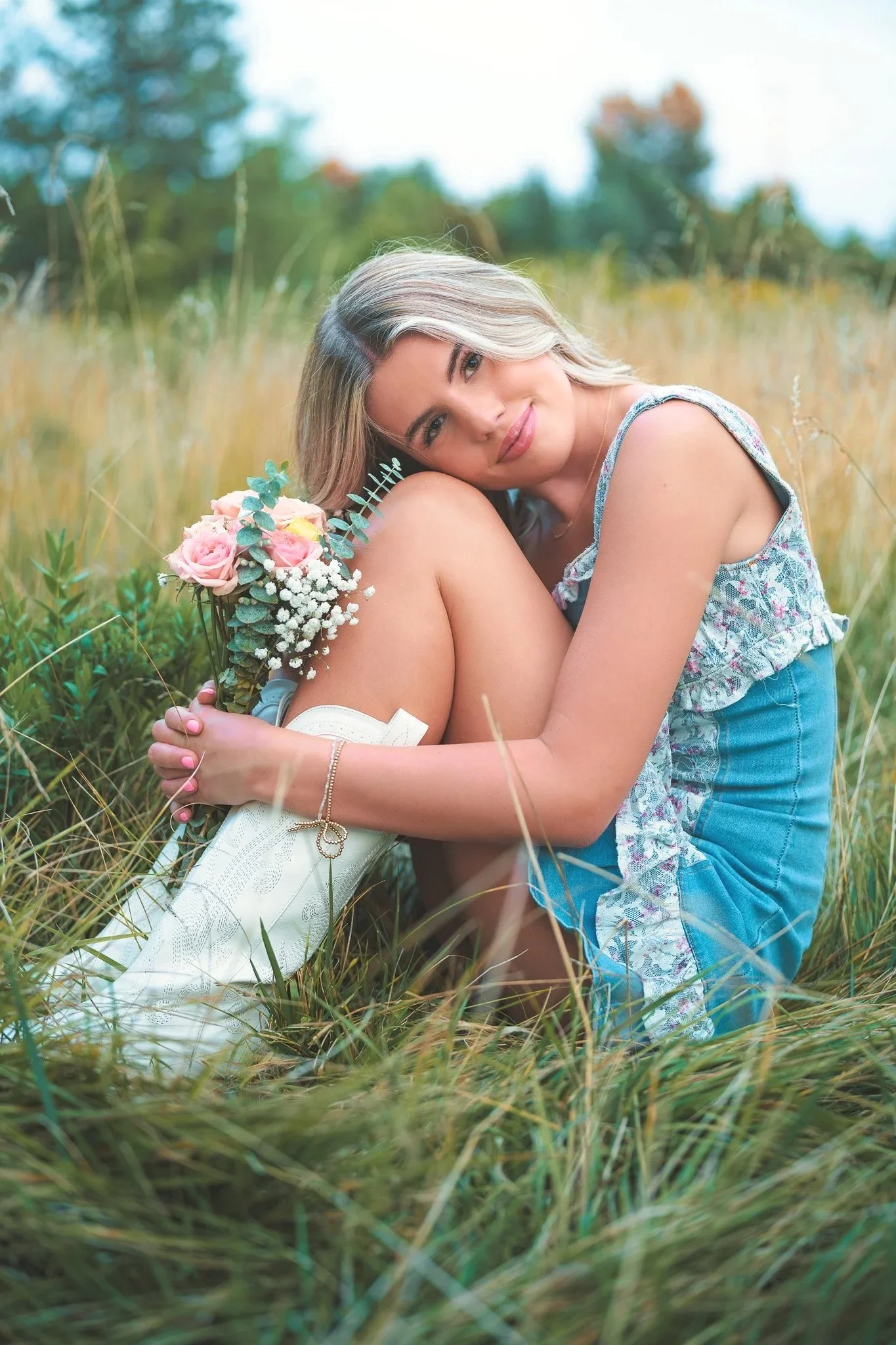 Senior photography session at Kathryn Albertson Park in Boise, with a high school senior in a floral dress holding roses in a natural grassy field — timeless Treasure Valley senior portraits serving Boise, Meridian, and Star.