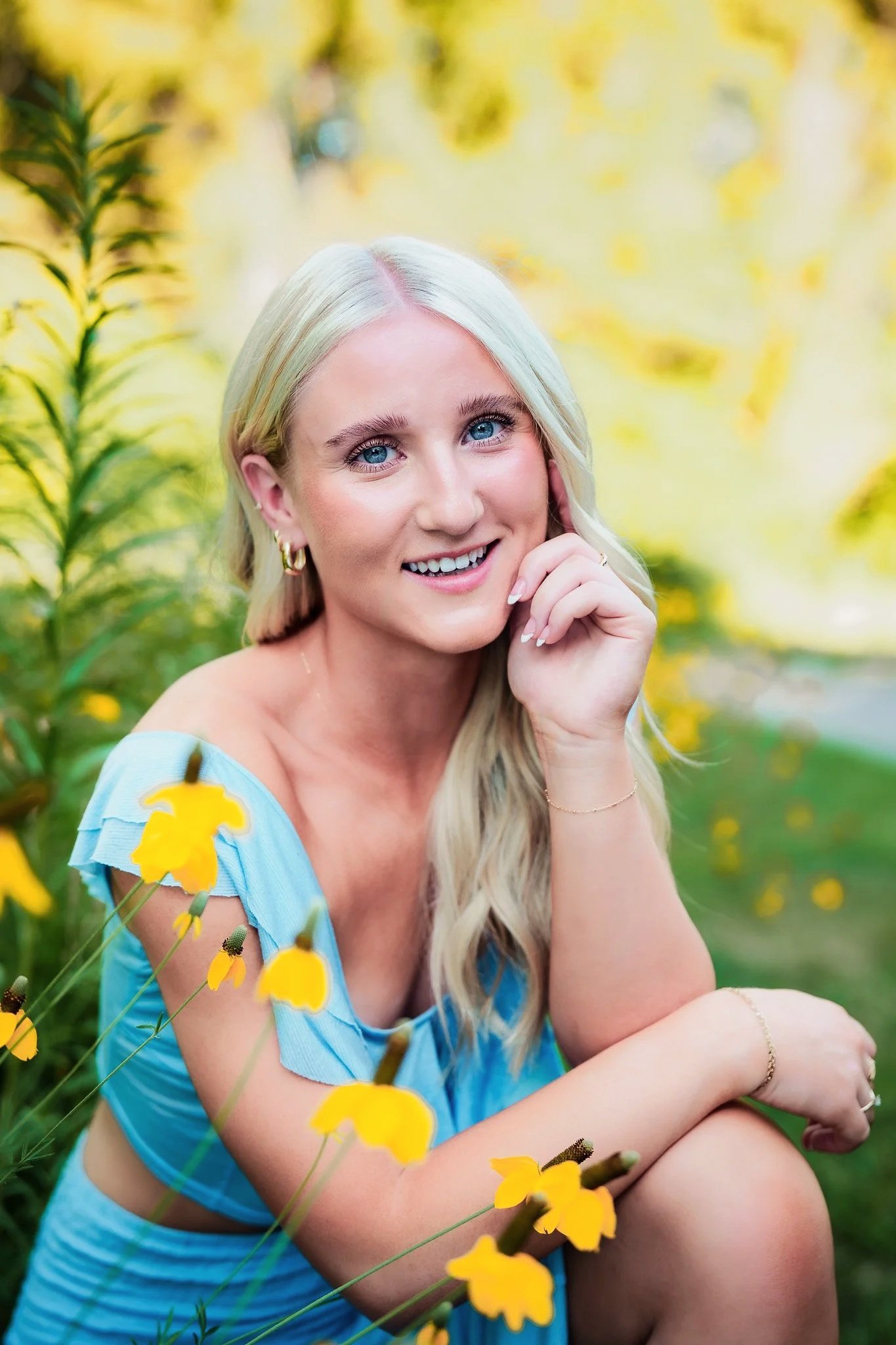 Senior girl in light blue dress surrounded by yellow wildflowers at Kathryn Albertson Park in Boise, Idaho – natural light senior portrait session.