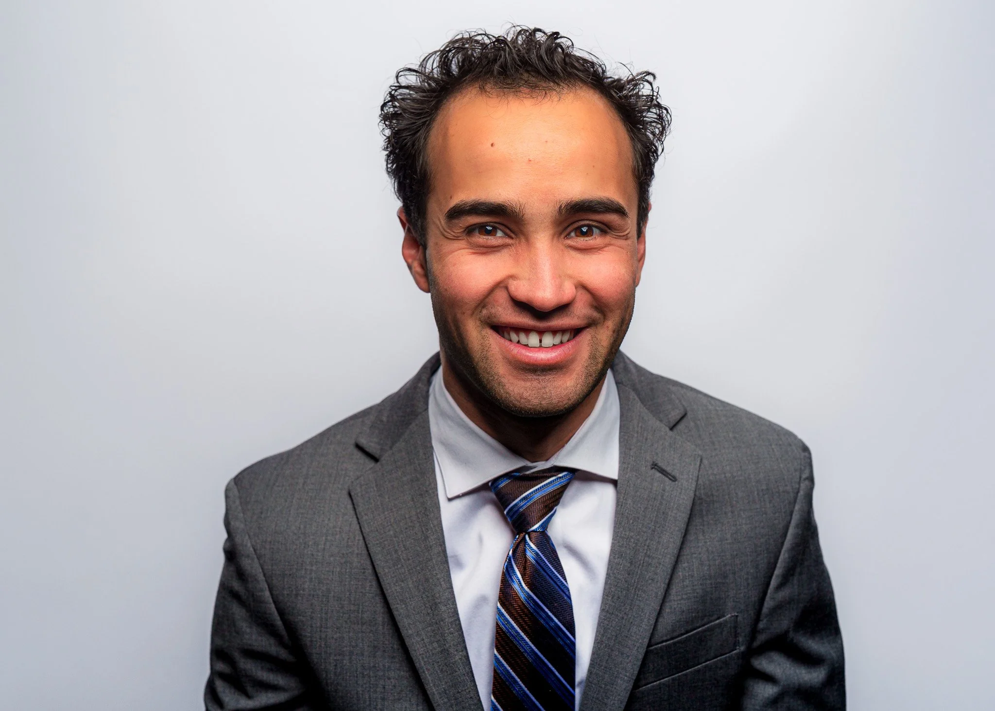 Professional headshot of a male client in a light blue shirt and tie, photographed on a clean white background in Boise, Idaho. Personal branding photography for professionals and entrepreneurs in Boise, Eagle, Meridian, Star, and the Treasure Valley