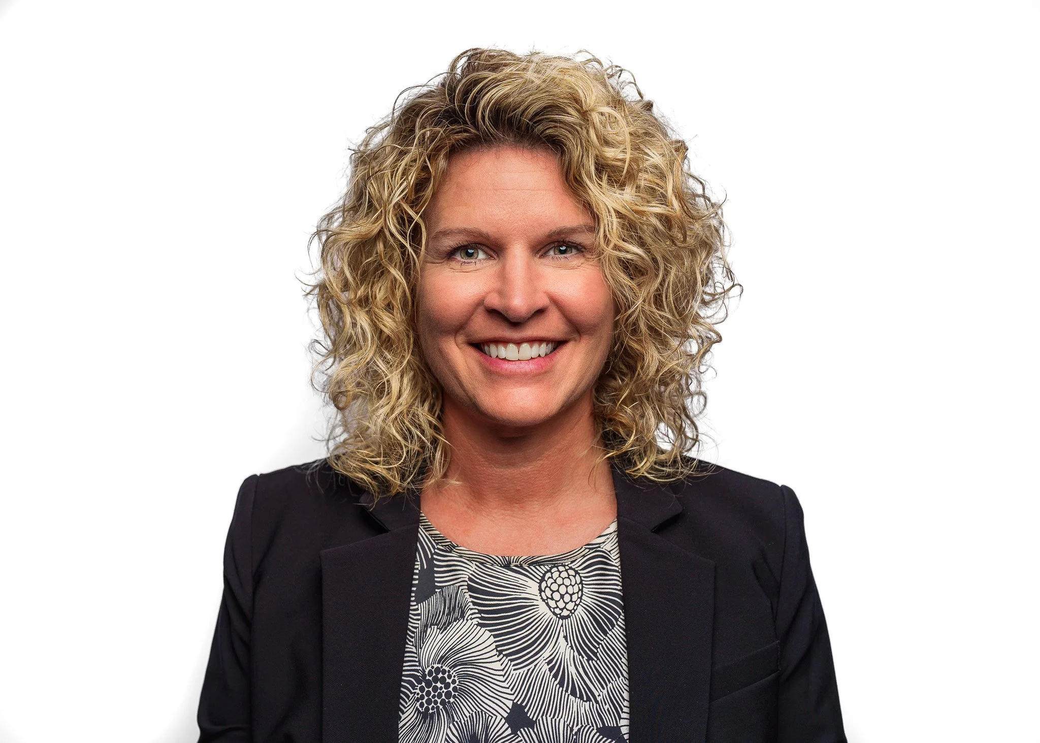 Professional headshot with a clean white background, showcasing a warm and approachable female client in a navy blazer. Branding portraits for business professionals and entrepreneurs in Boise, Meridian, Eagle, Star, and the Treasure Valley. Forever 