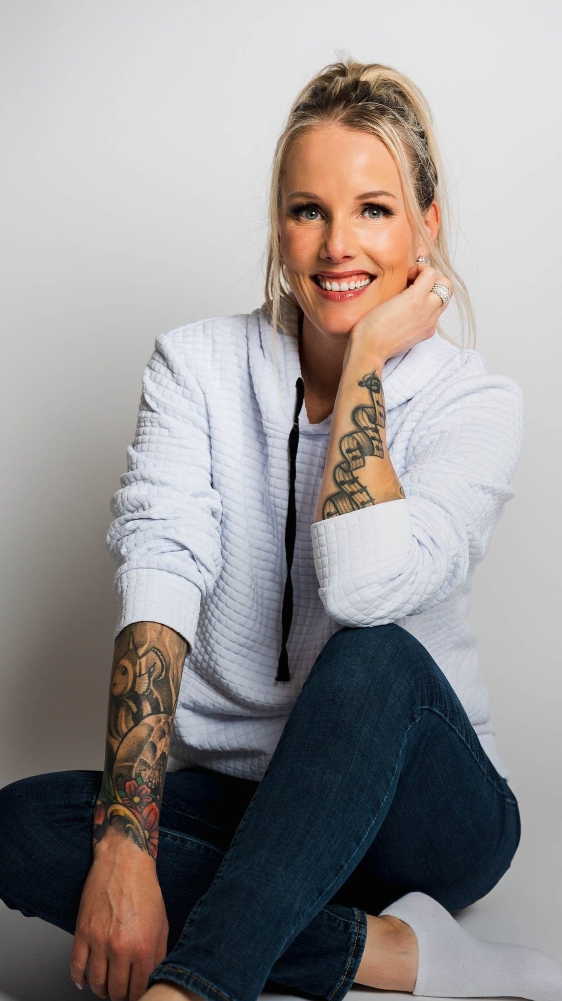 Jennifer LeMaster senior photographer and Forever My Media owner smiling confidently in jeans and white button-down.