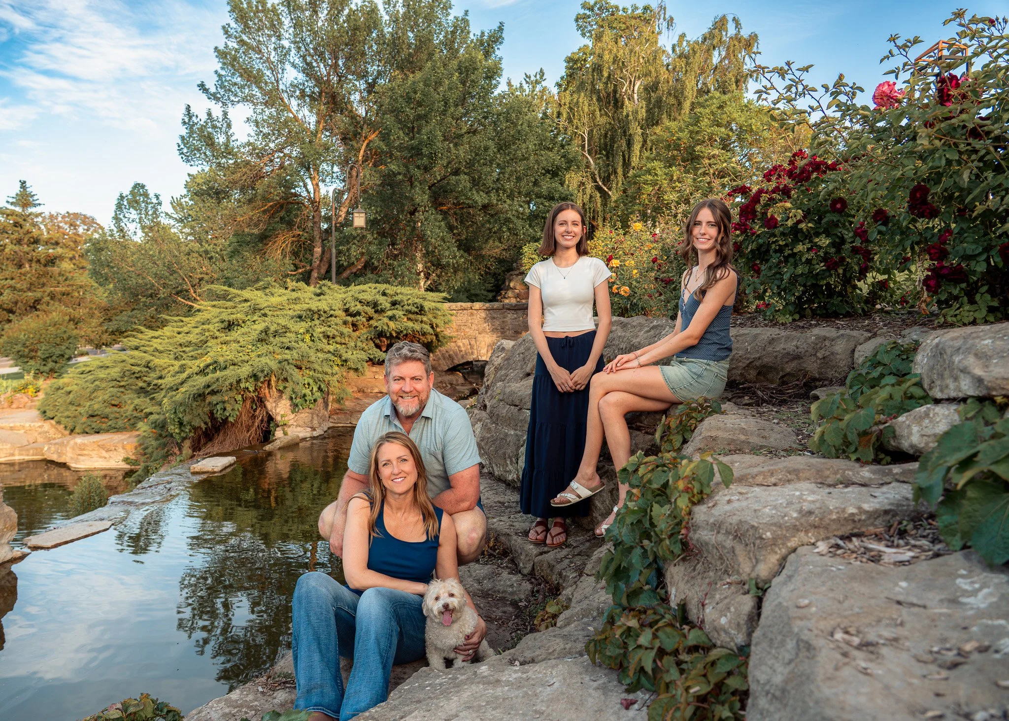Candid family portrait at the Boise Rose Garden, featuring warm evening light, natural stone textures, and vibrant summer blooms. This relaxed session highlights authentic connection and playful moments, perfect for capturing timeless family memories
