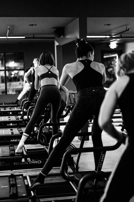 Dynamic black-and-white action shot from a Karve Gym fitness class in Eagle, Idaho. Capturing the energy, strength, and movement of boutique group training in a modern studio space. Fitness and wellness branding photography for Karve Lagree studio an