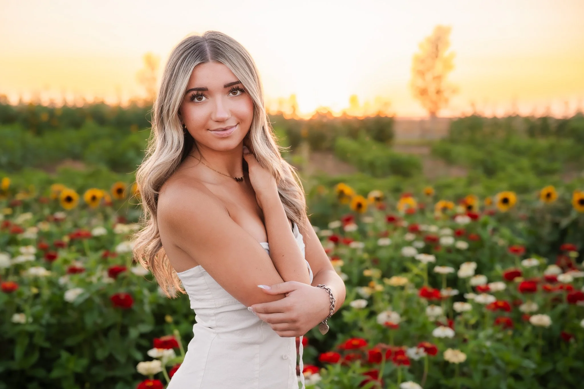 Senior photos captured in Lowe family farm with a beautiful senior in all white with flowers in the background. Eagle, Boise and Meridian Photographer
