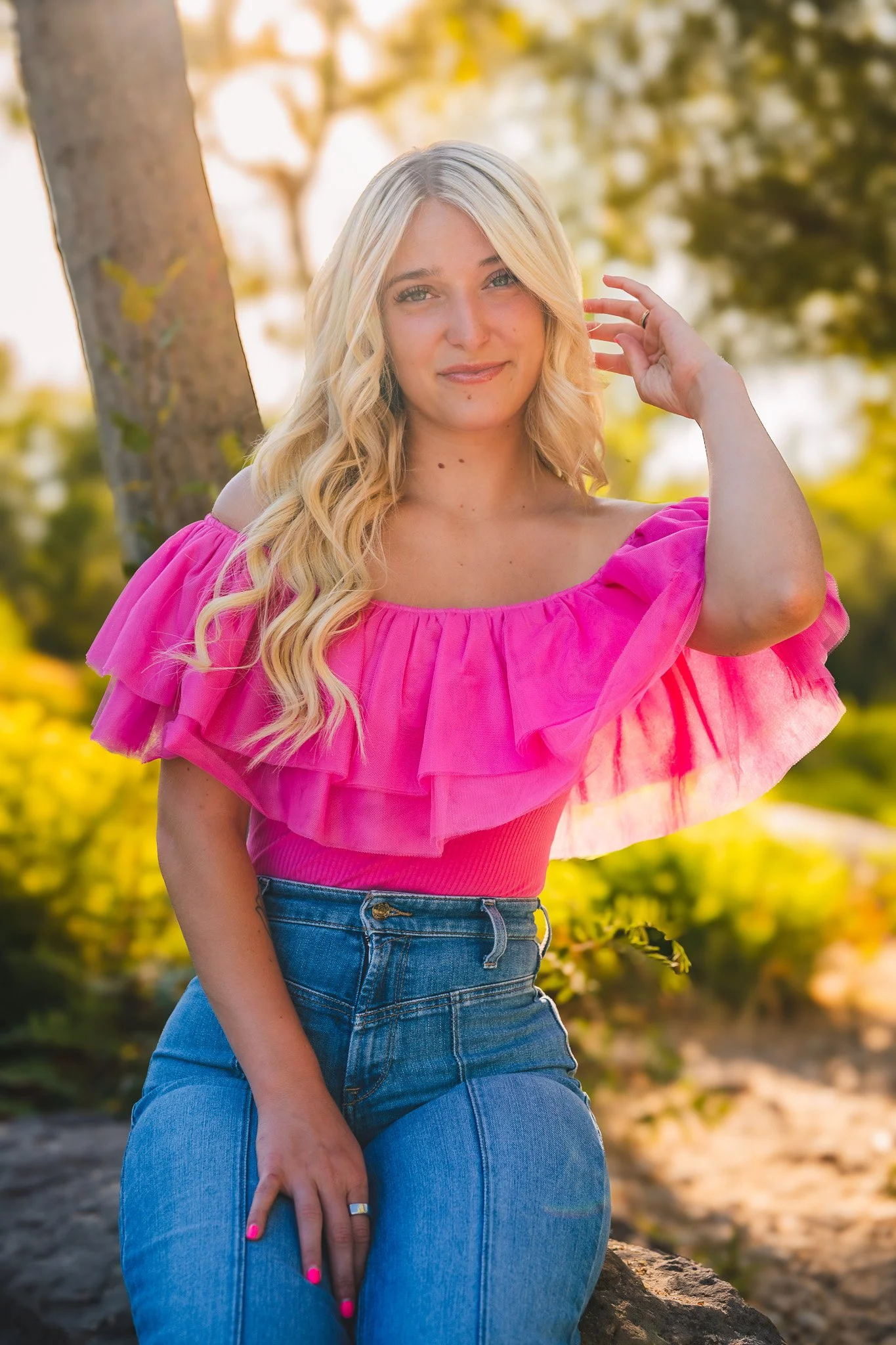 his senior portrait was captured along the Eagle Greenbelt in Eagle, Idaho — a perfect blend of golden light, lush summer greens, and bold personal style. Her bright pink top and confident presence made this session stand out. If you're looking for s