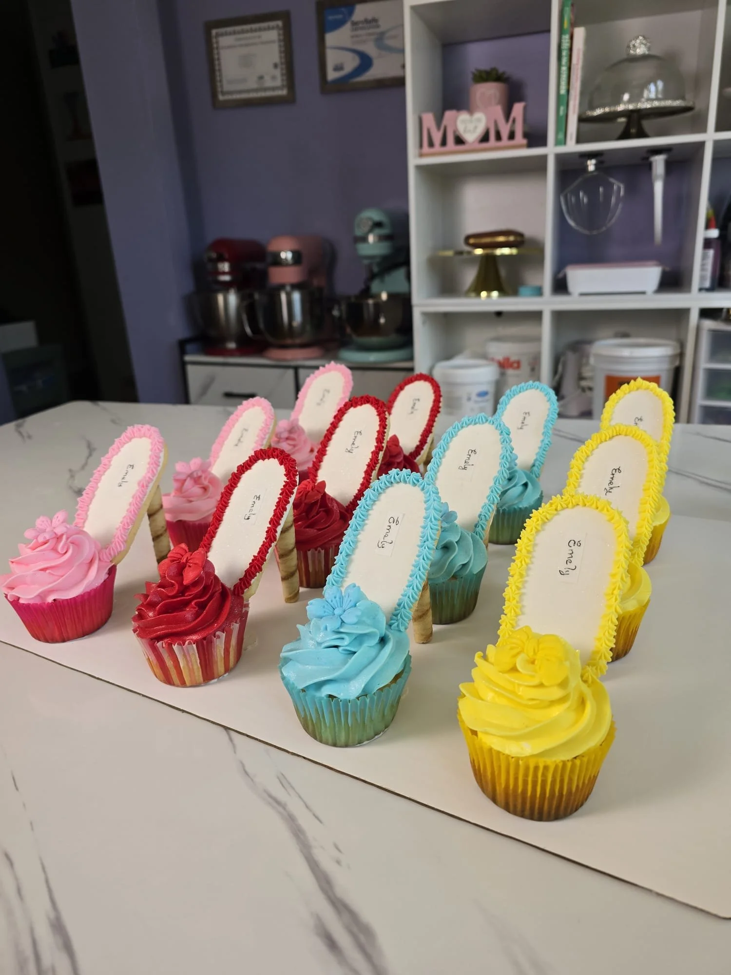 Delicias de cupcakes decorados con colores pastel y etiquetas de mensaje, en diferentes colores (rosado, rojo, azul y amarillo).