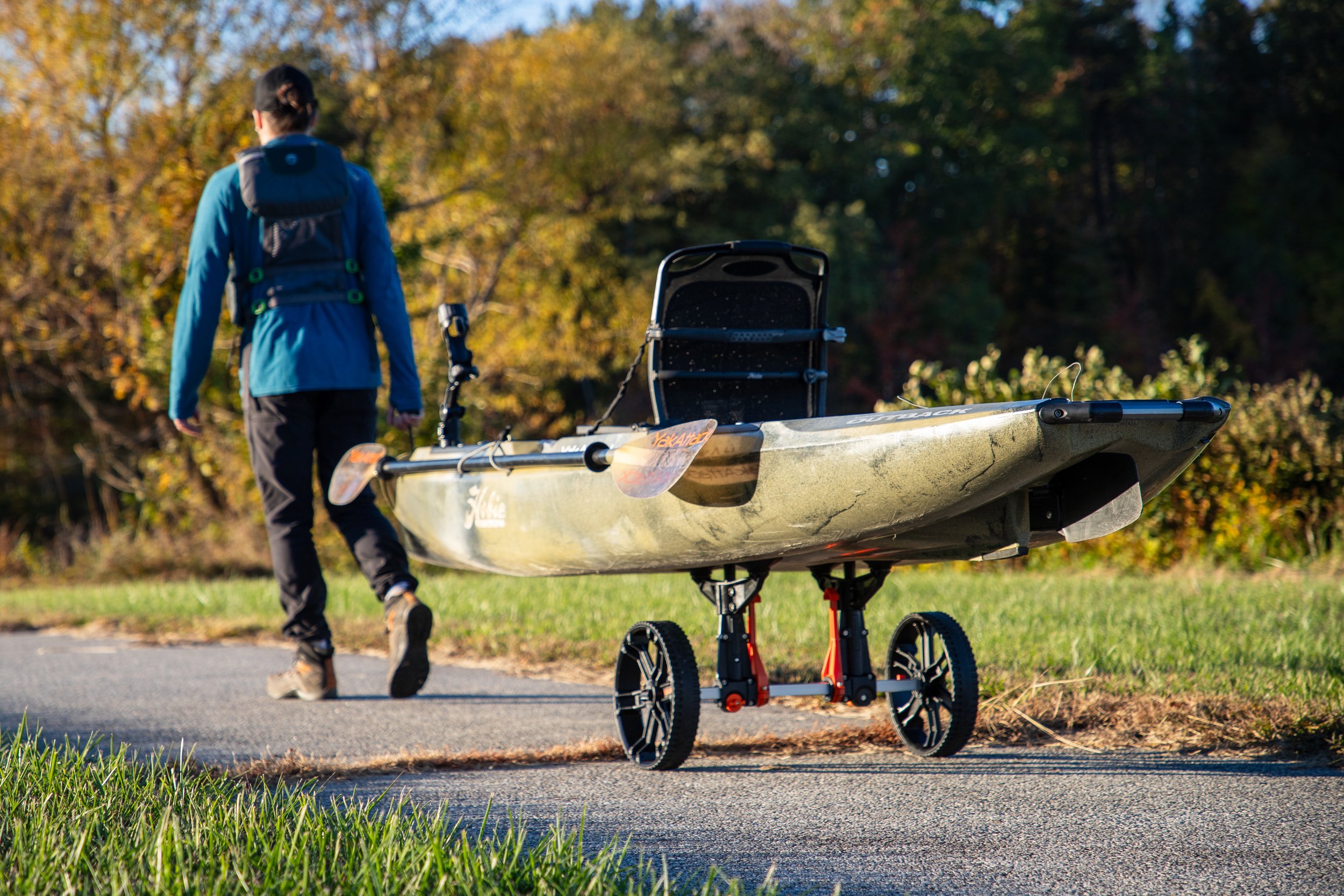 User pulling Hobie Outback kayak using Tow N Stow Scupper Cart