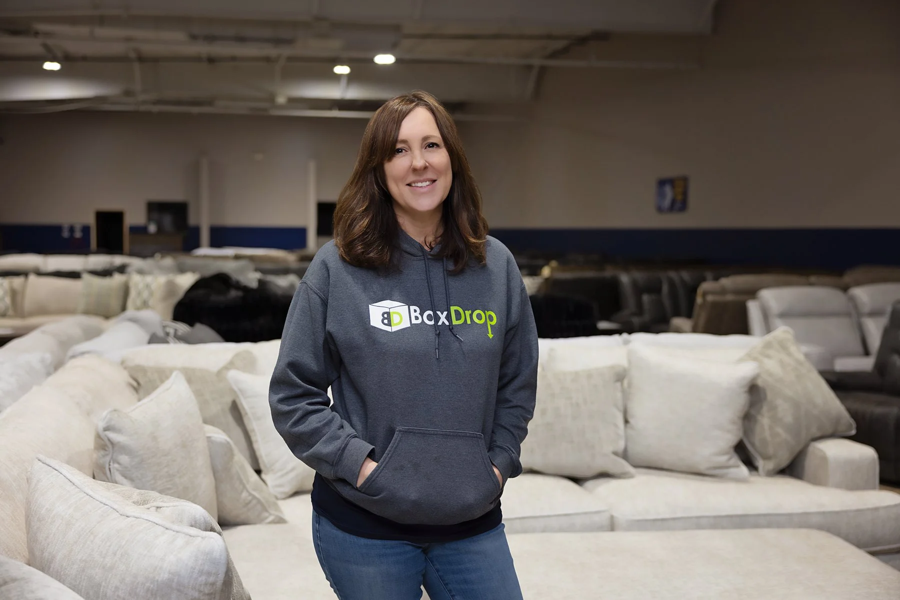 The owner of Alexandria, LA Box Drop company smiling and wearing a grey sweatshirt with the Box Drop logo.