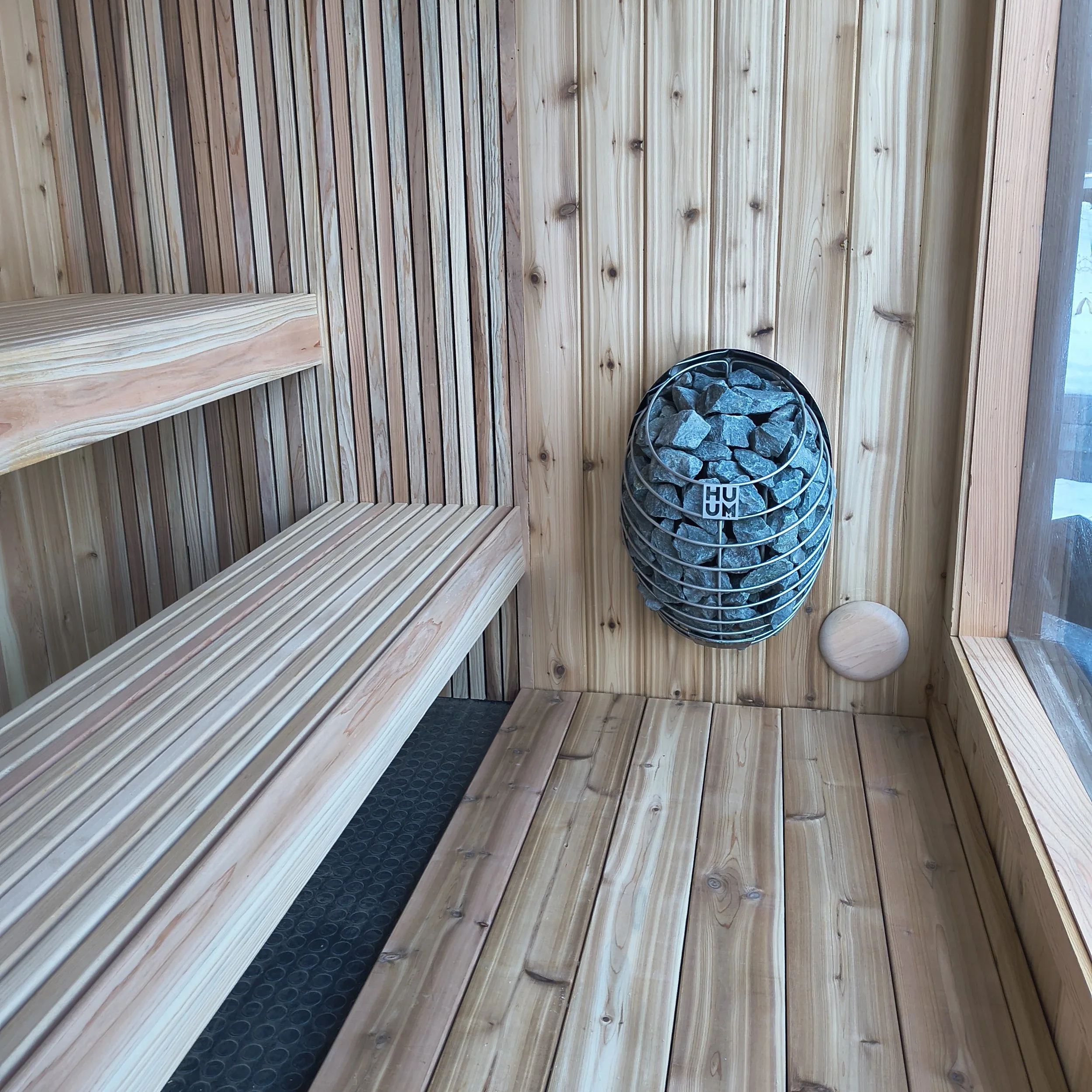 Interior of sauna cedar benches HUUM heater vented hot room